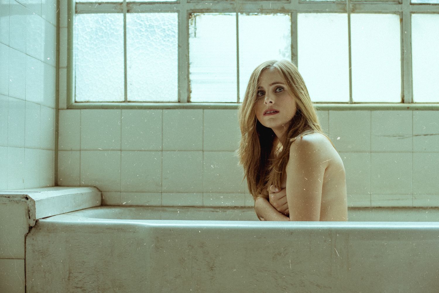 Vintage style bathtub portrait with natural window lighting.