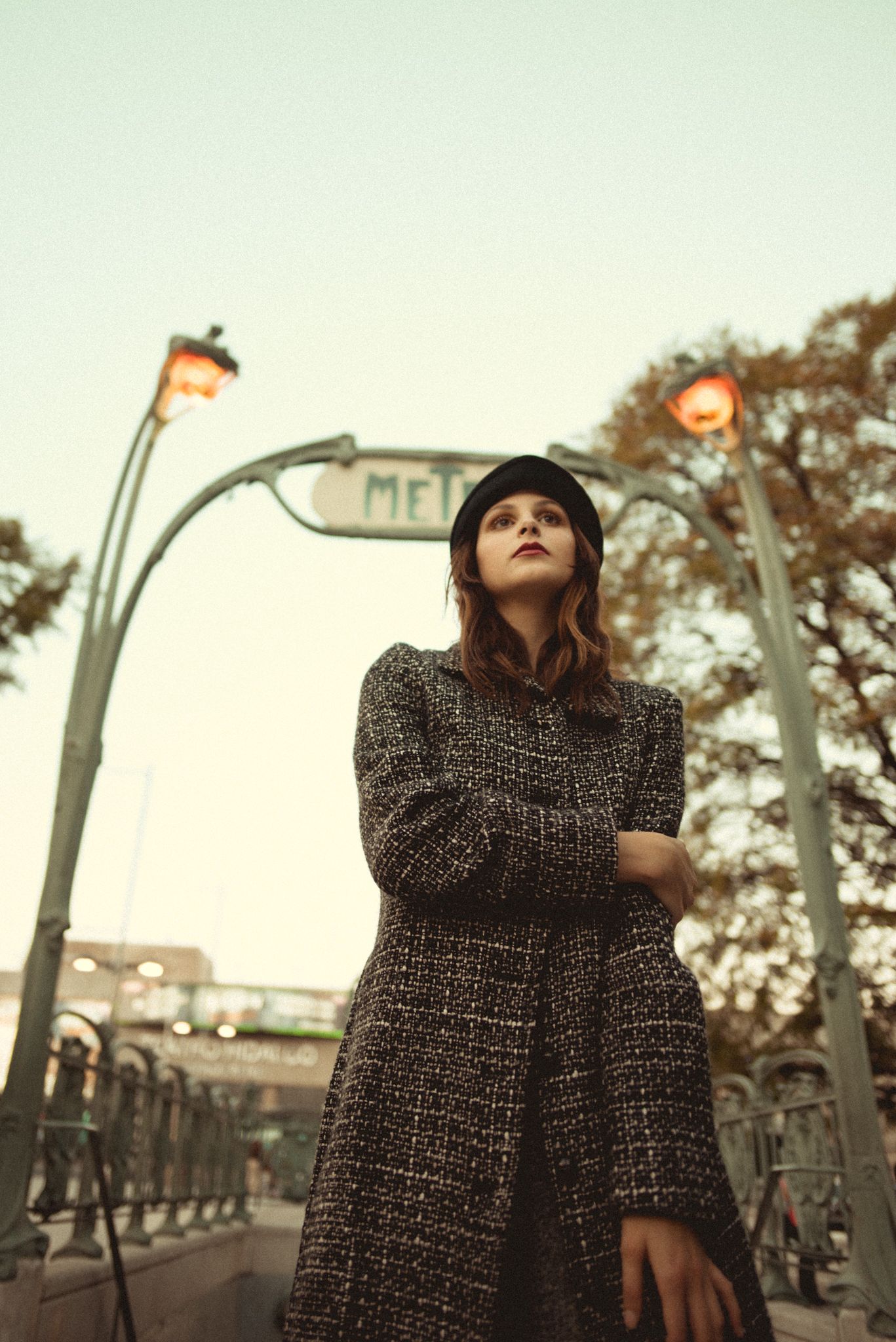 Moody street fashion photograph with vintage metro entrance and twilight lighting.