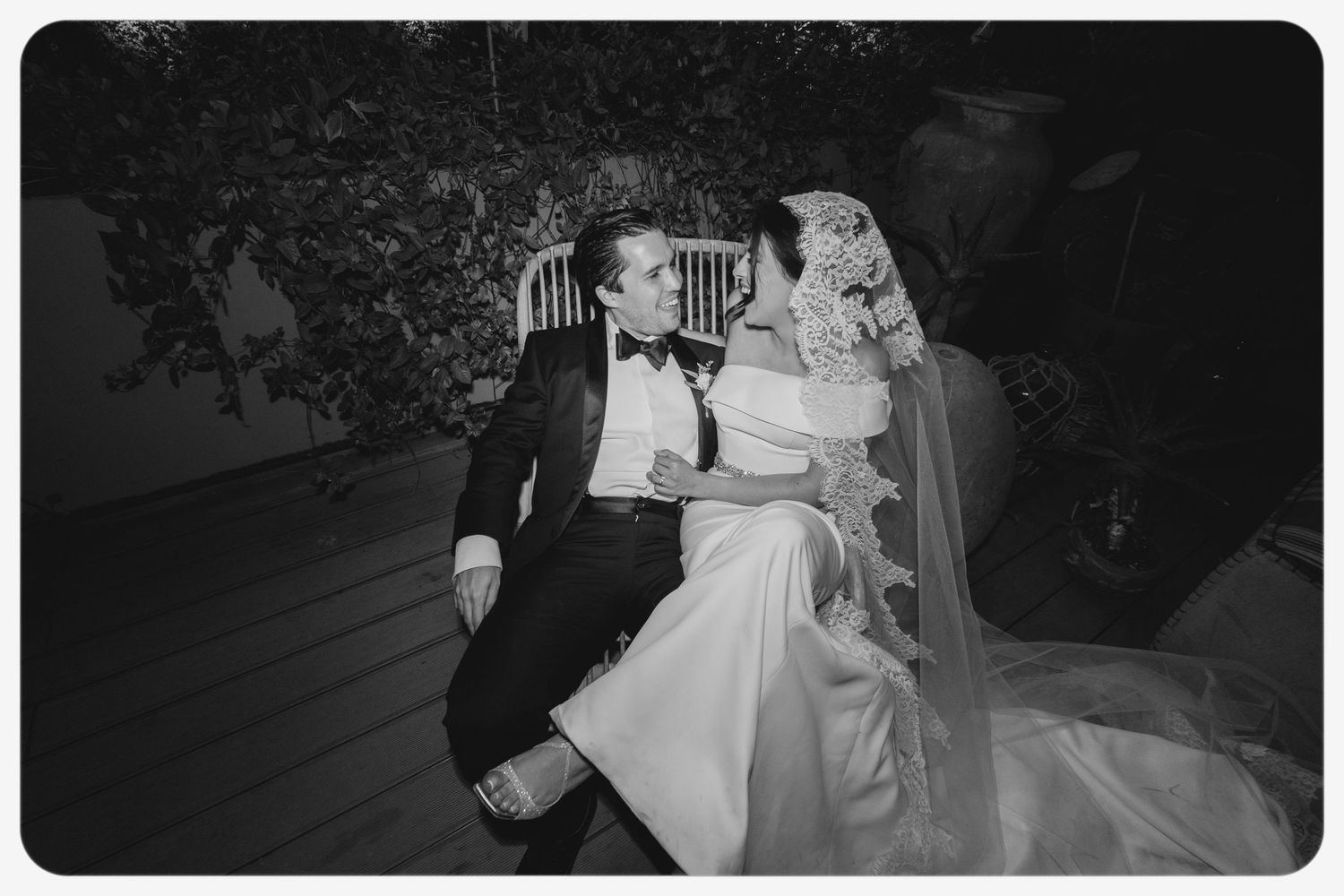 Vintage-style black and white photo of couple resting on outdoor patio.