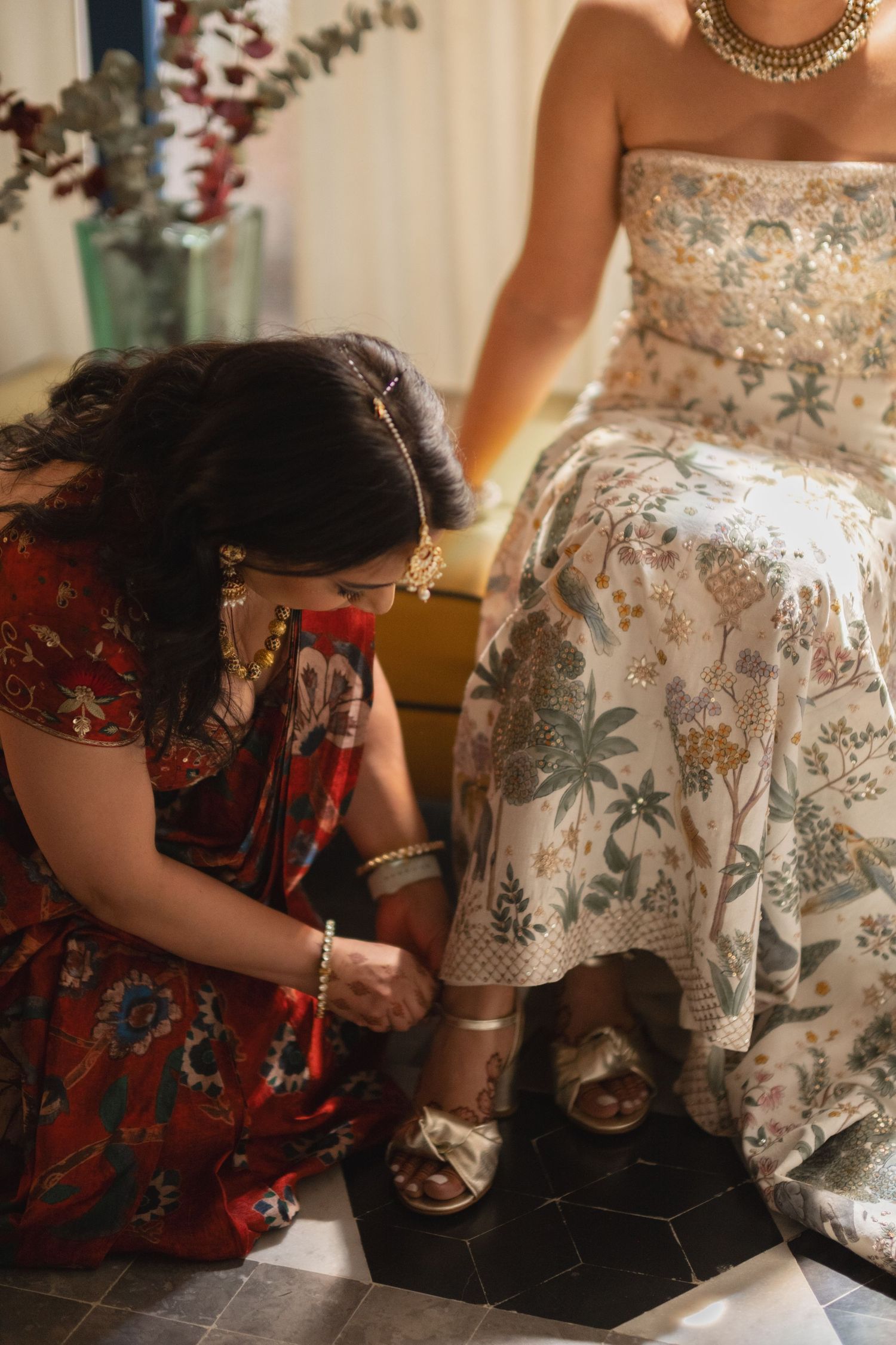 Close-up of intricate beadwork and floral details on wedding dress during preparation.
