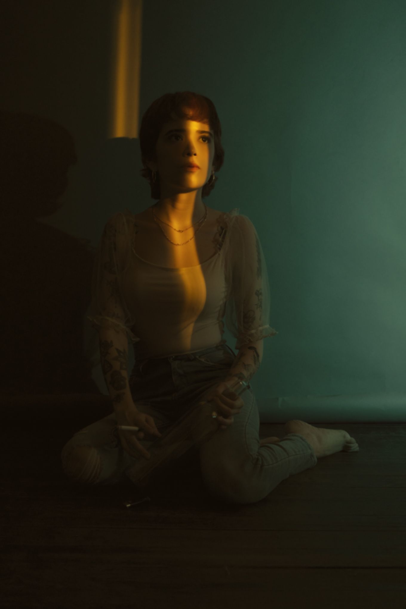 Atmospheric portrait in muted lighting with teal and amber color gradient.