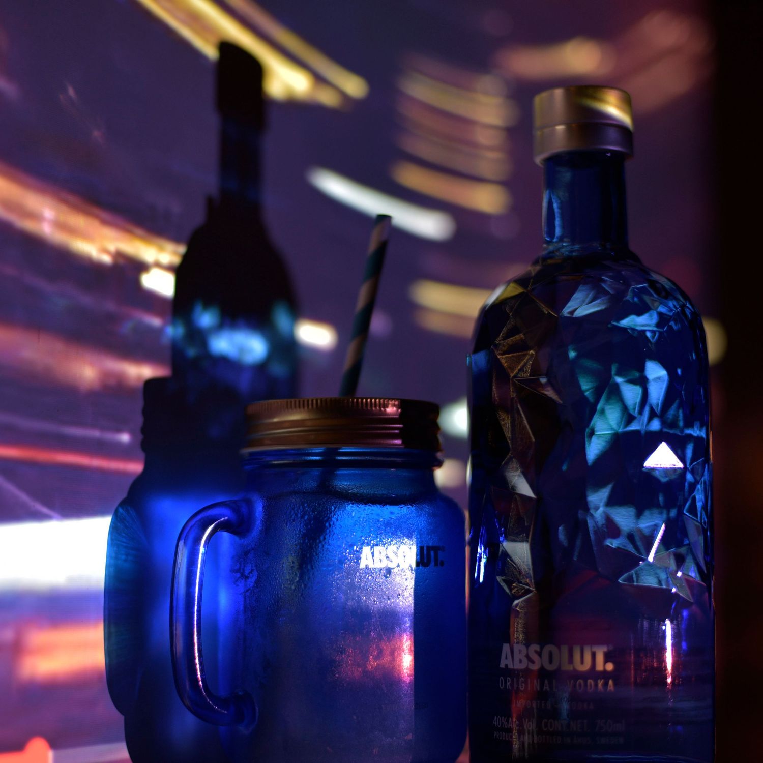 Dramatic nightclub scene with blue-lit vodka bottles creating atmospheric lighting and reflections.