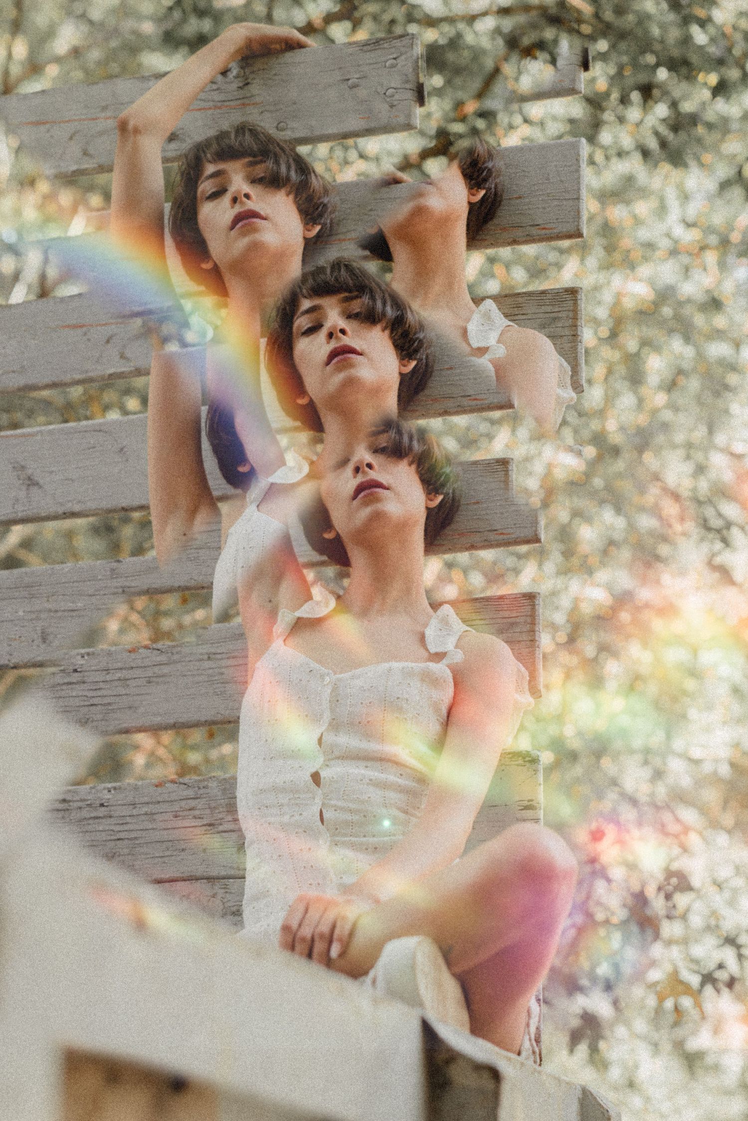 Artistic triple exposure portrait with rainbow light leaks and wooden backdrop.