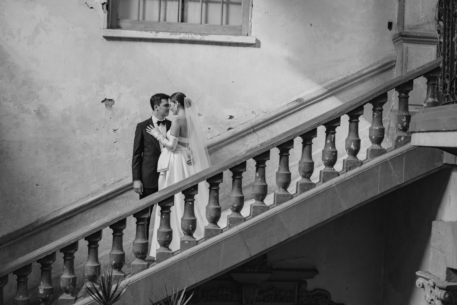A black and white wedding portrait captured on an elegant stone staircase.
