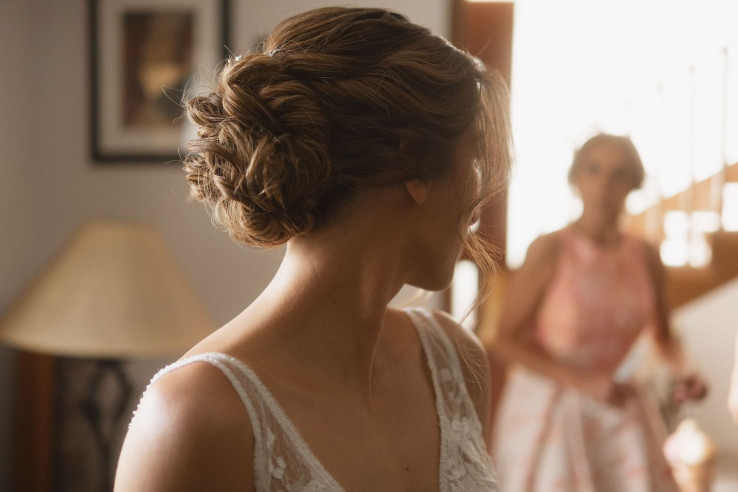 Elegant updo hairstyle detail from behind with soft window lighting.