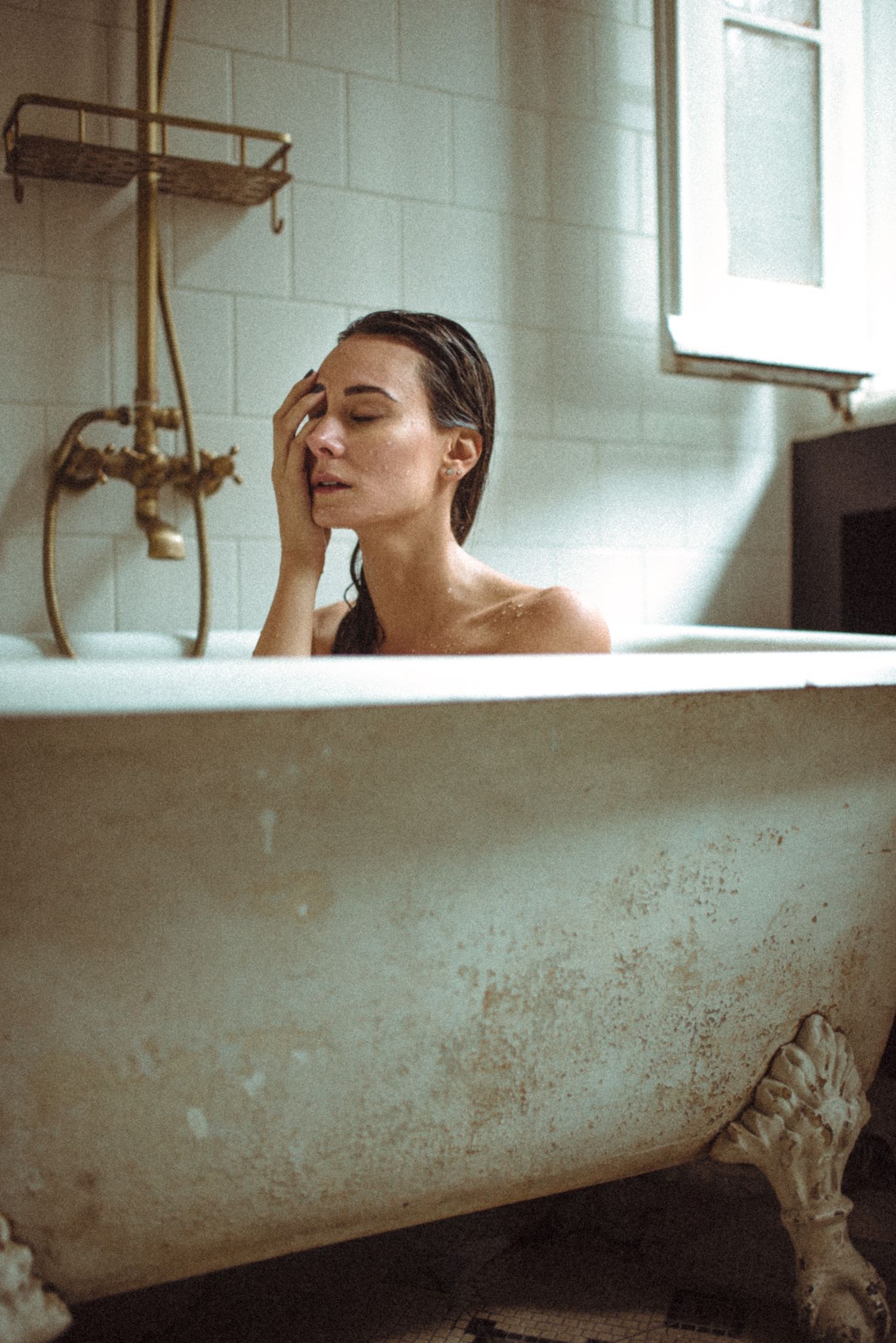 Vintage-style photo of relaxing bath scene in antique clawfoot tub.