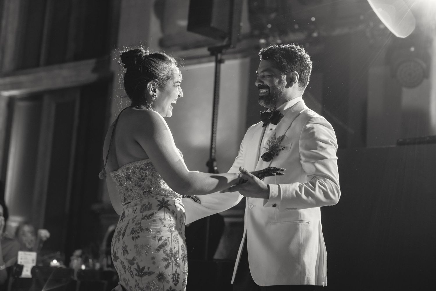 Romantic black and white wedding dance moment captured under venue lighting.