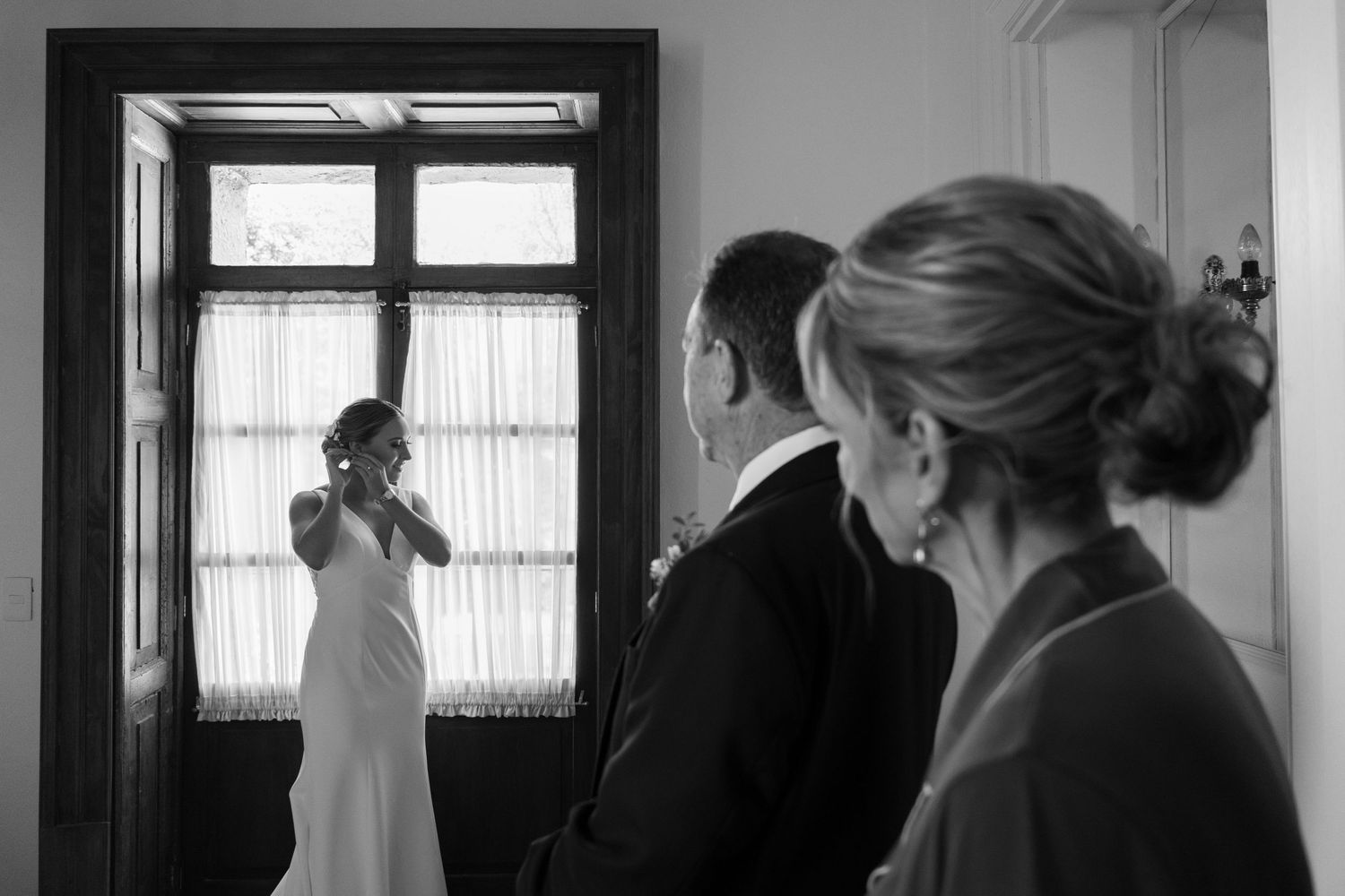 Black and white photo showing wedding scene through door frame.