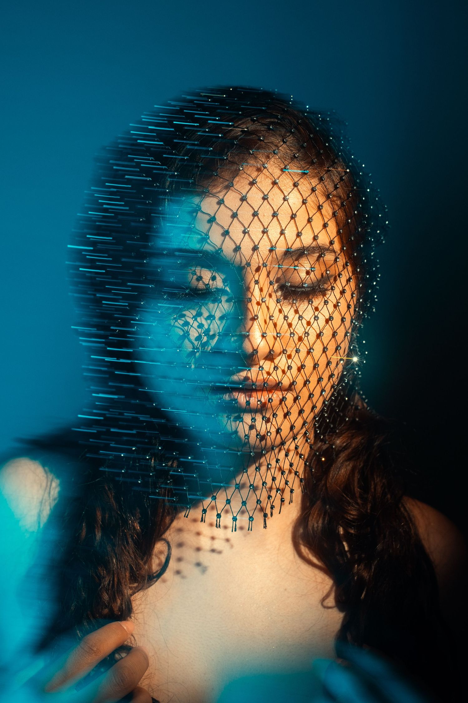 Creative portrait using fishnet texture overlay and blue lighting effects.