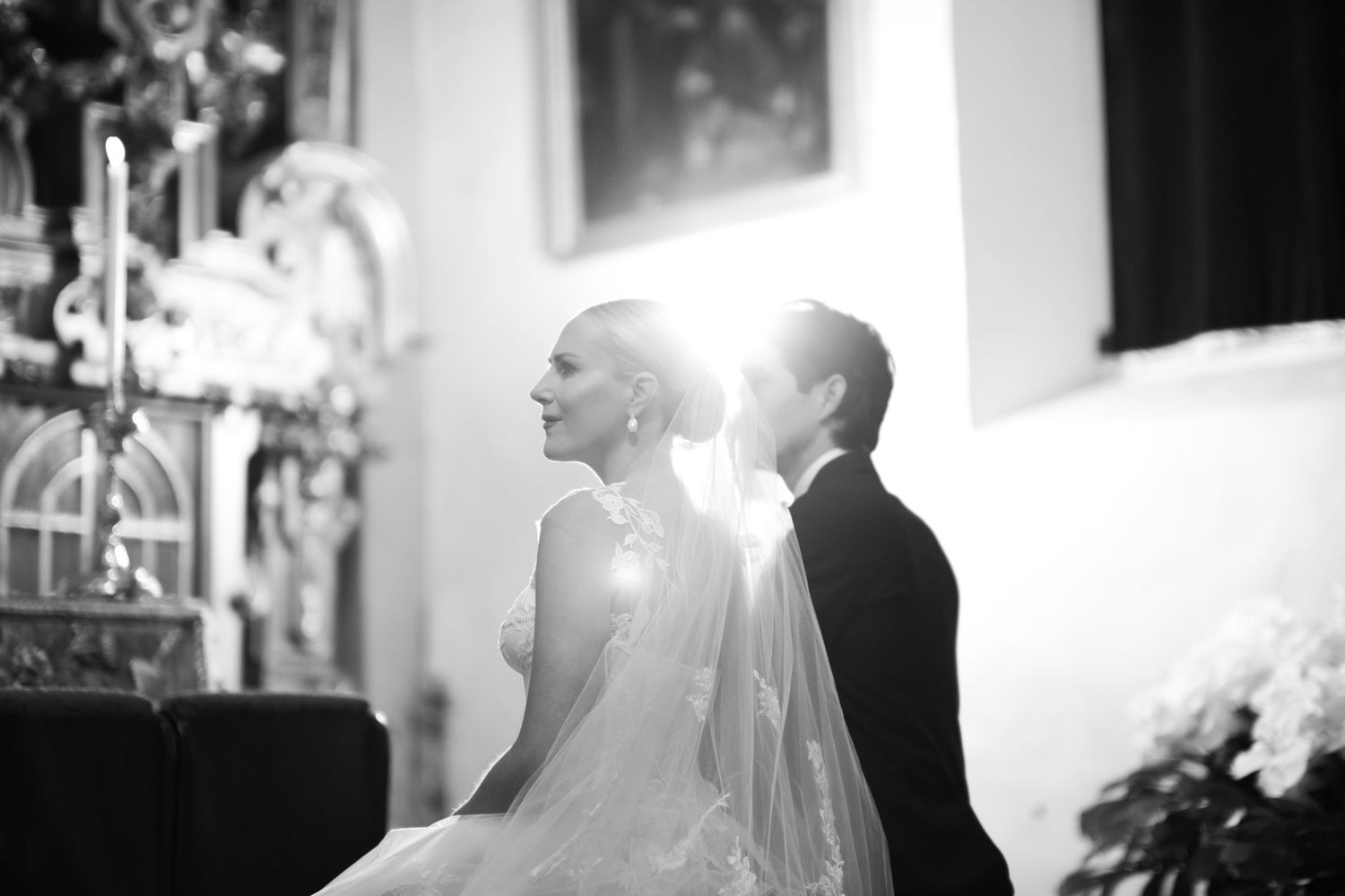 Dramatic black and white silhouette of newlyweds with light streaming through.