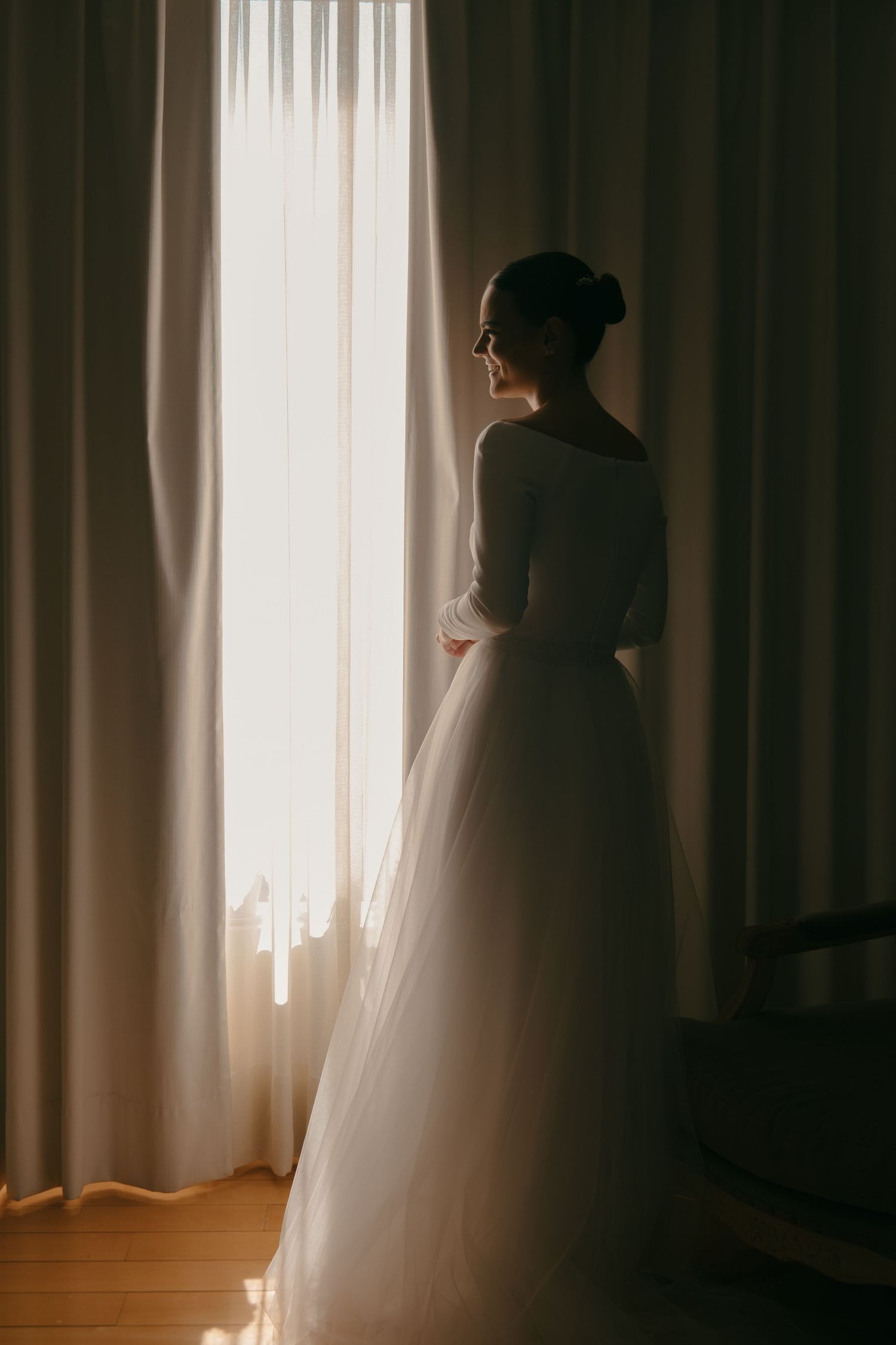 Side profile silhouette of a person in formal attire against window light.