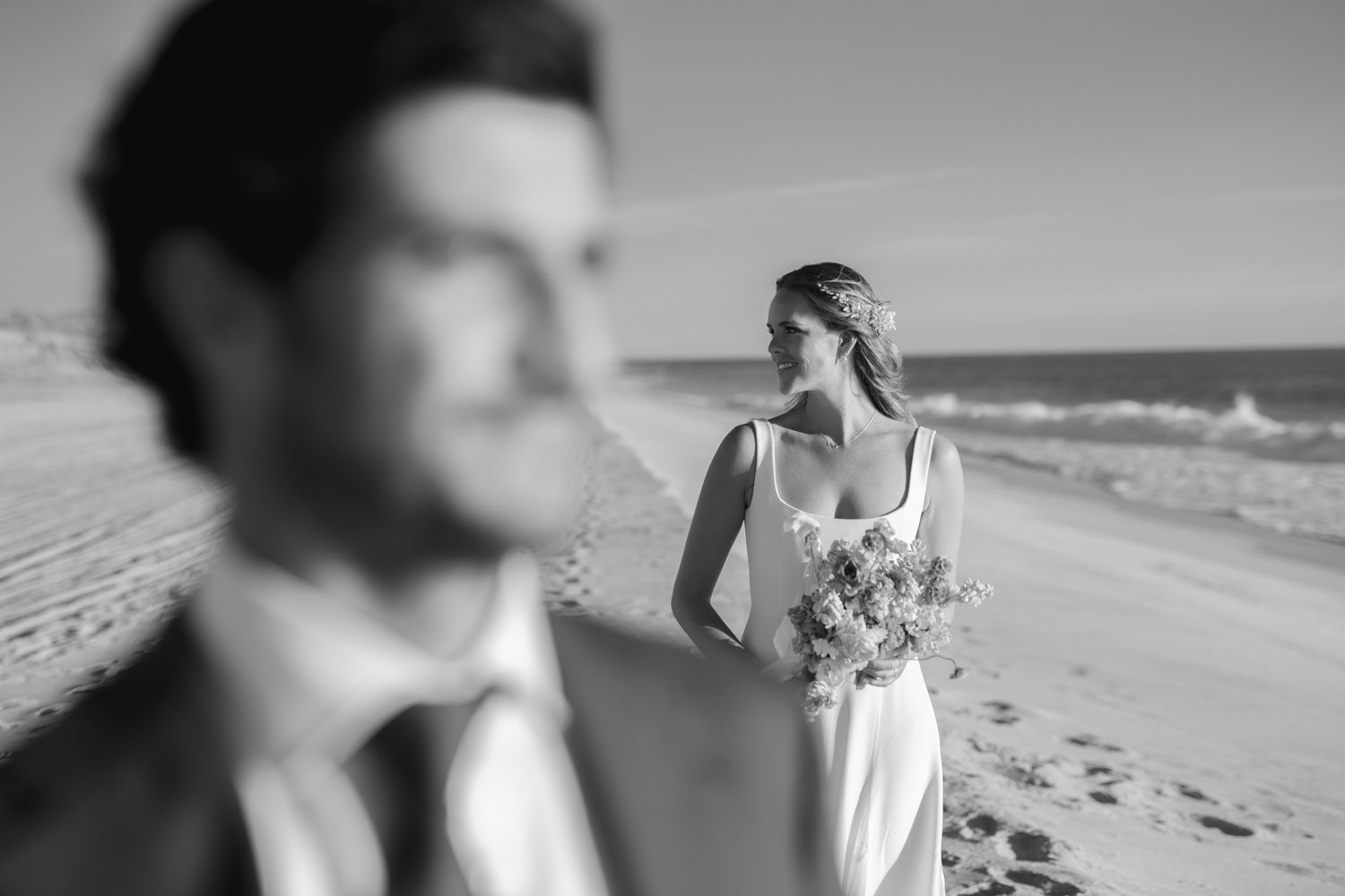 An artistic beach wedding photo with selective focus and coastal scenery.