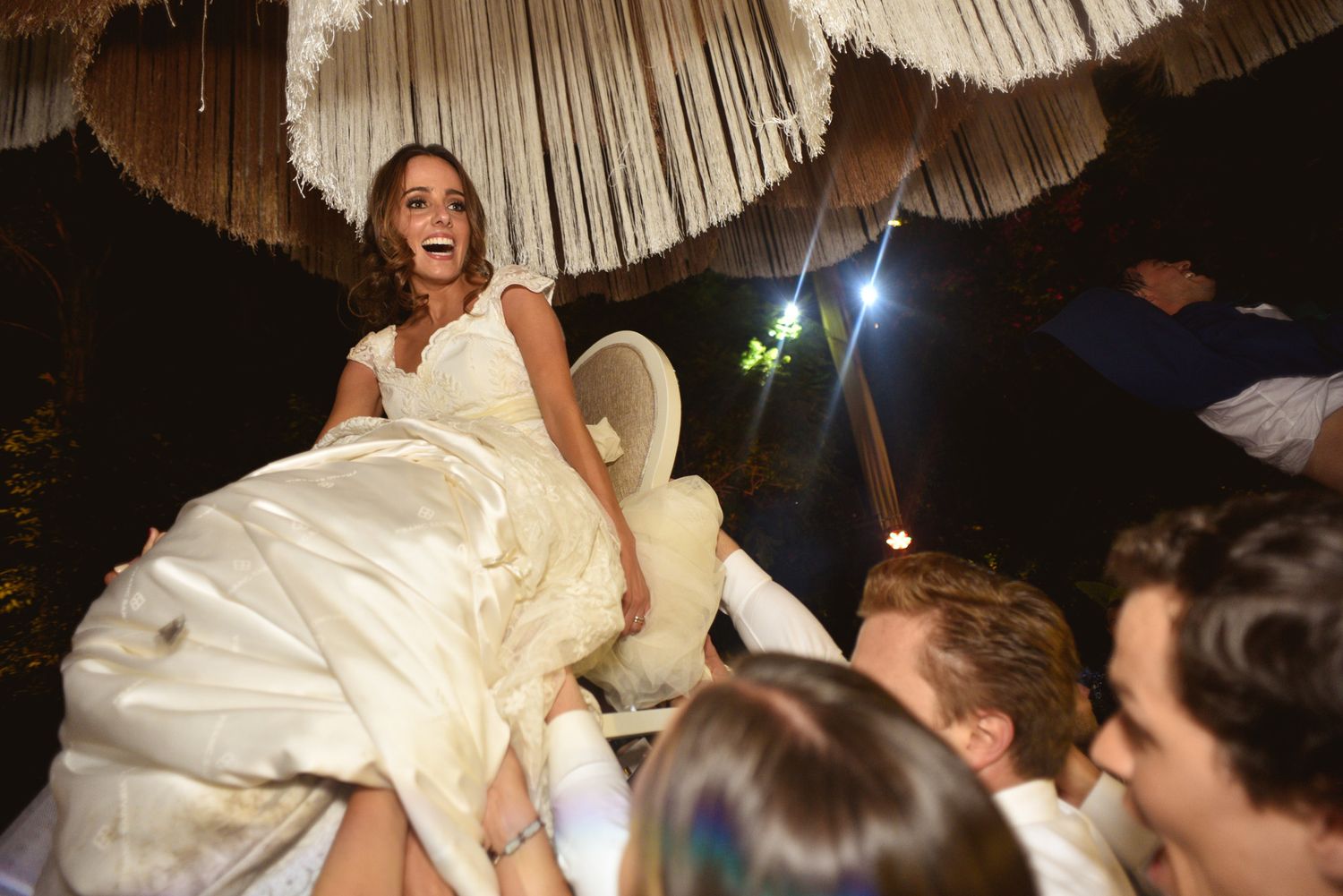 A joyful celebration moment during a wedding reception with hanging decorative elements.