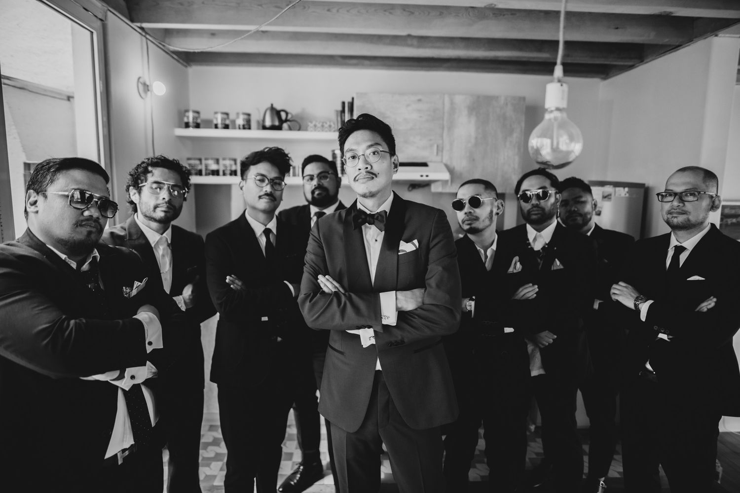 A black and white photograph shows a group of men in formal attire gathered together in what appears to be a social setting.