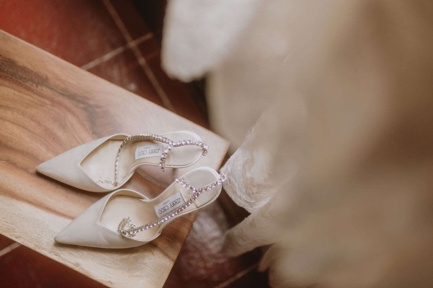 Detail shot of elegant white bridal shoes with rhinestone embellishments.