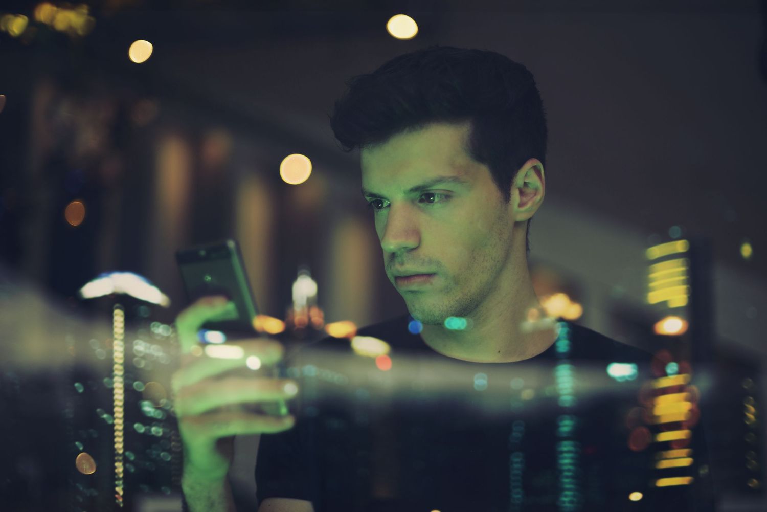 Dimly lit bar scene with cocktail glass reflecting ambient lighting.