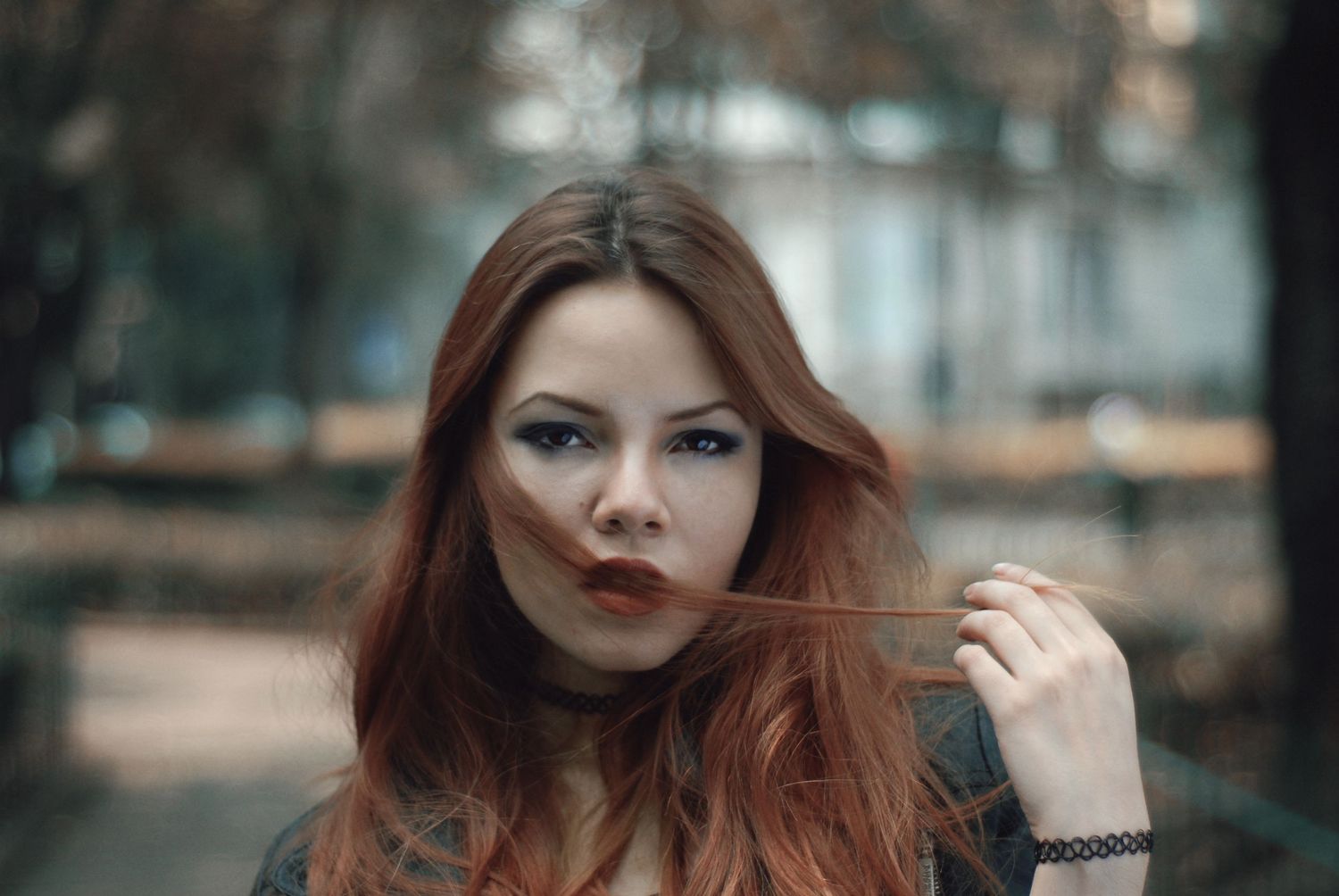 Atmospheric portrait of a redhead in autumn with soft lighting.
