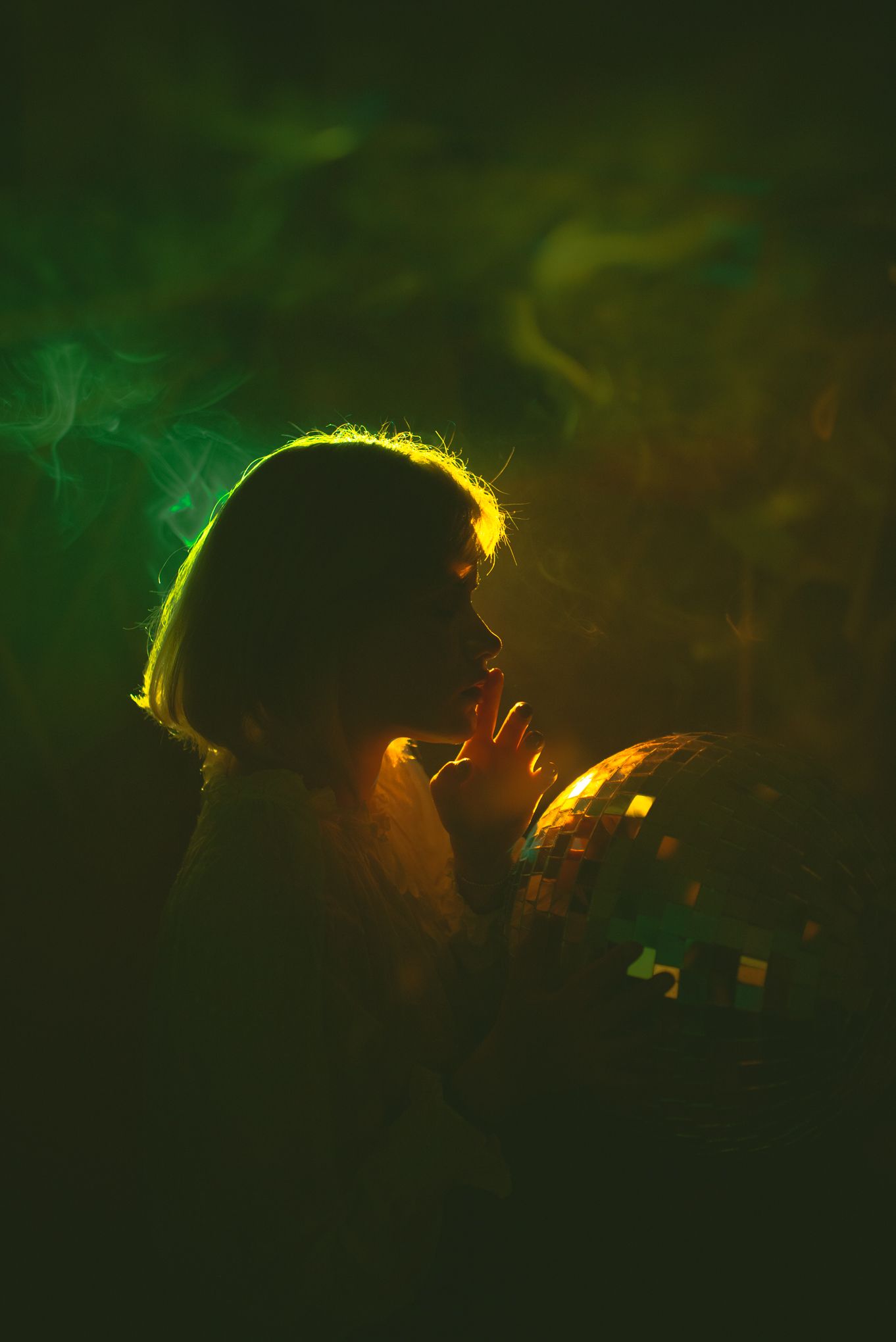 Backlit silhouette in green and yellow lighting with smoke effects.