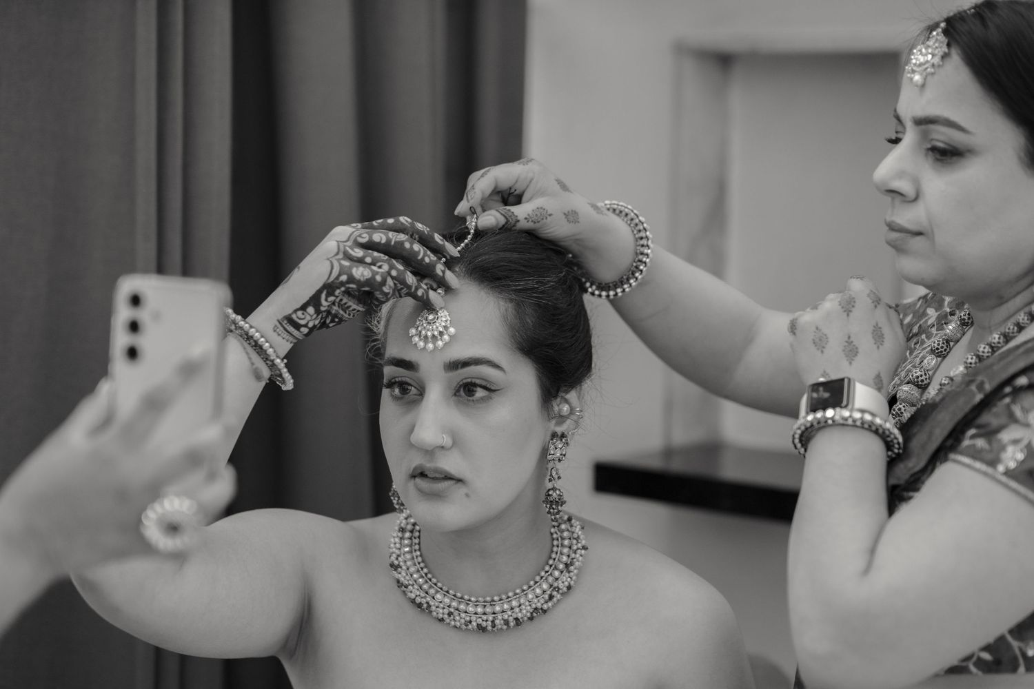 Traditional Indian wedding preparation showing detailed jewelry and accessory styling.
