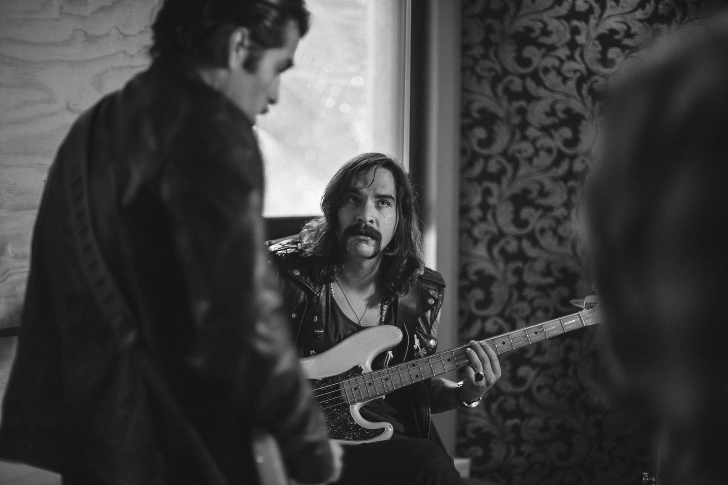 Dark atmospheric photo of musicians performing with focus on guitar player.