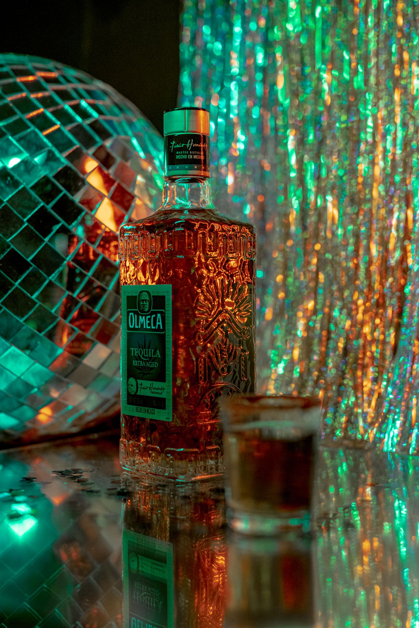 Decorative bottle photographed with disco ball and green party lighting effects.