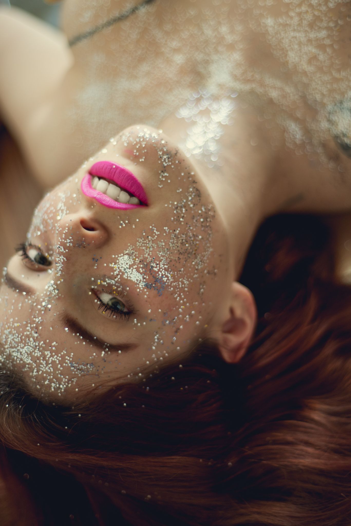 Close-up beauty portrait featuring pink lips and sparkling glitter makeup.