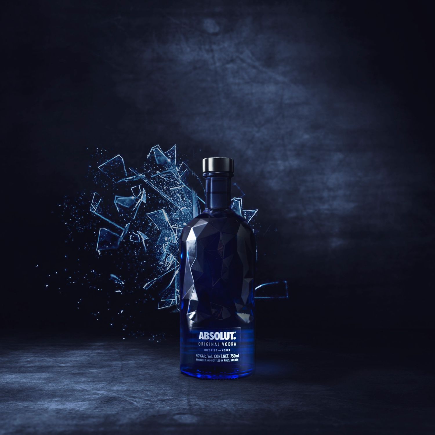 Absolut vodka bottle photographed in dark lighting with glowing blue liquid effects and glass shards creating an artistic scene.