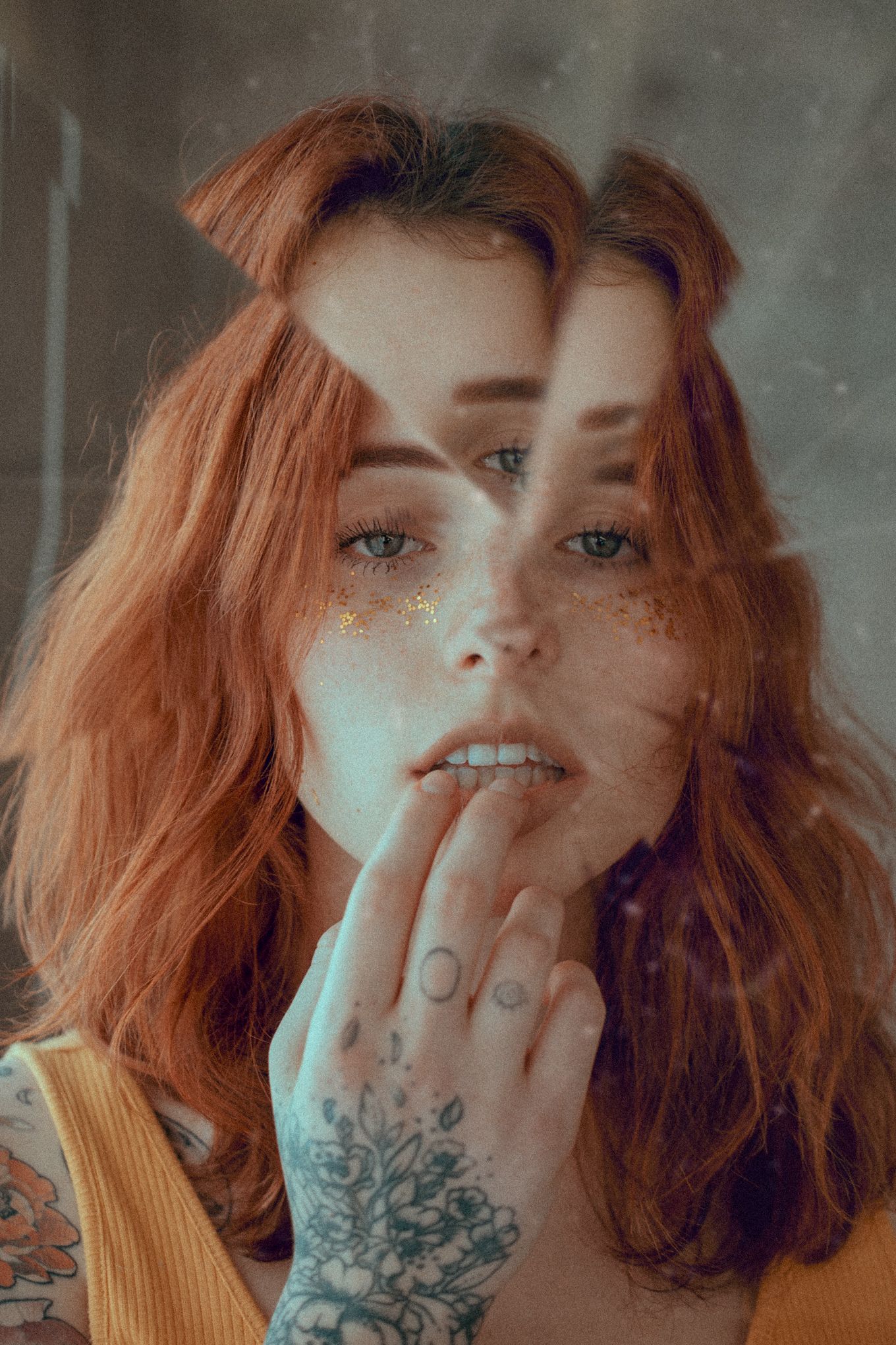 Close-up portrait with freckles, tattoos and ginger hair in double exposure effect.