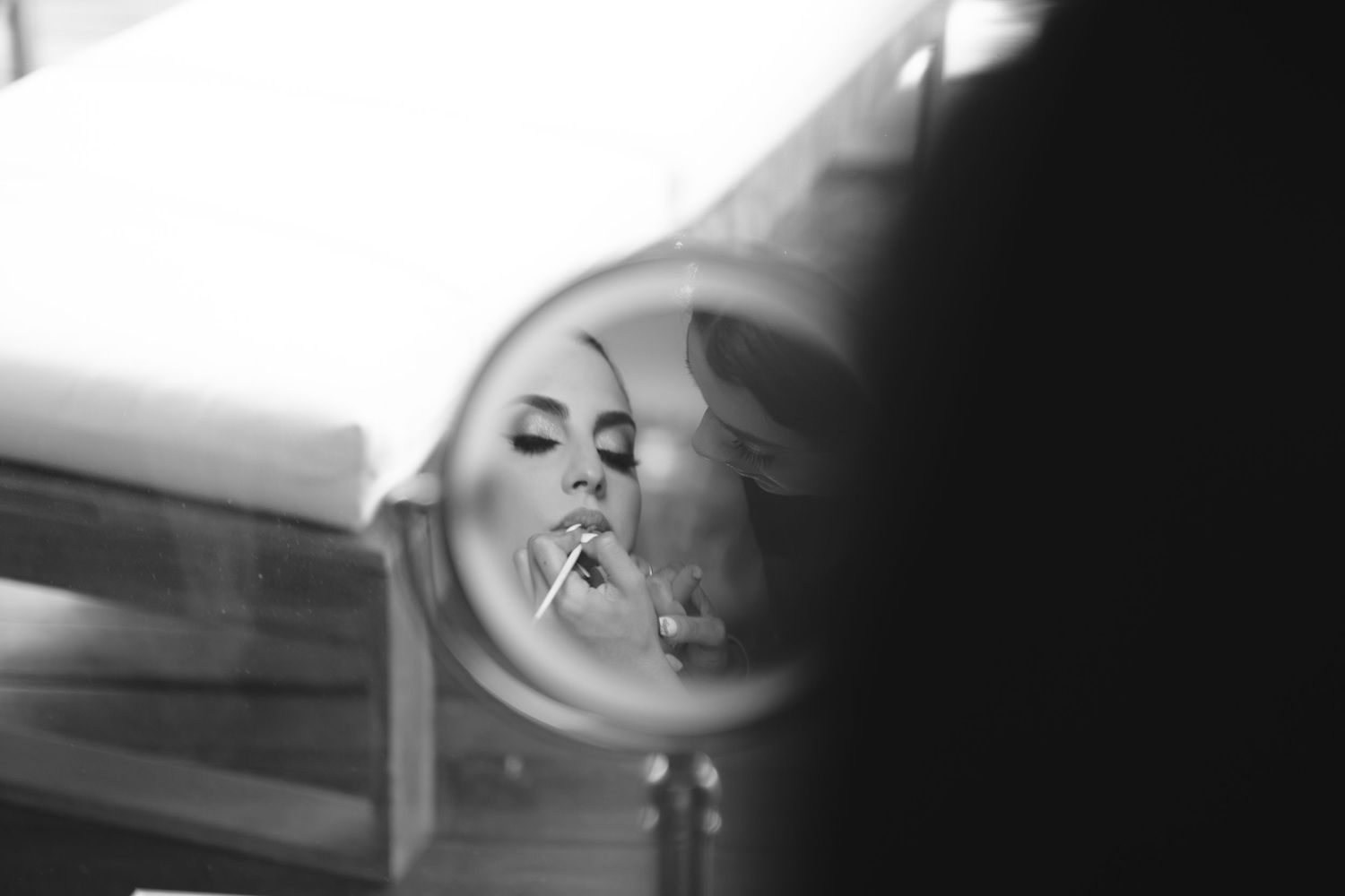 Artistic black and white reflection in a round mirror with dramatic lighting.