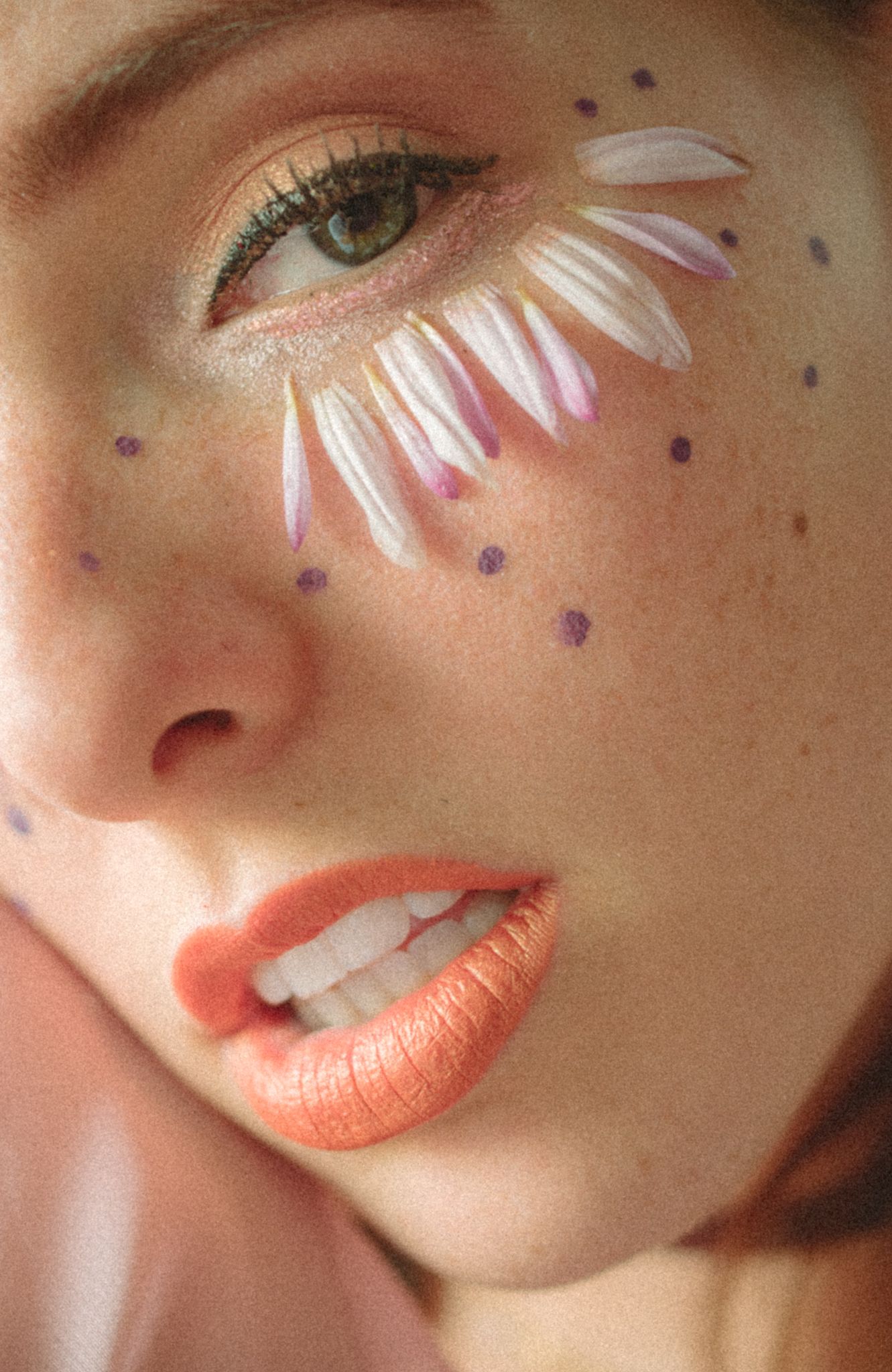 Creative beauty makeup with white petal design and glitter dots around eye with coral lipstick.
