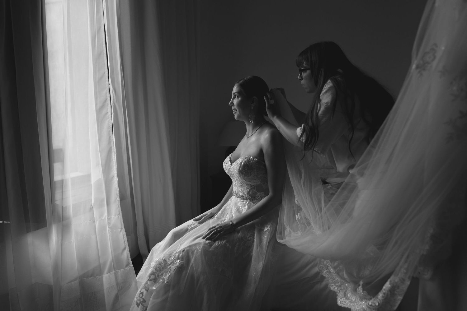 A quiet moment of wedding preparation captured in dramatic black and white.