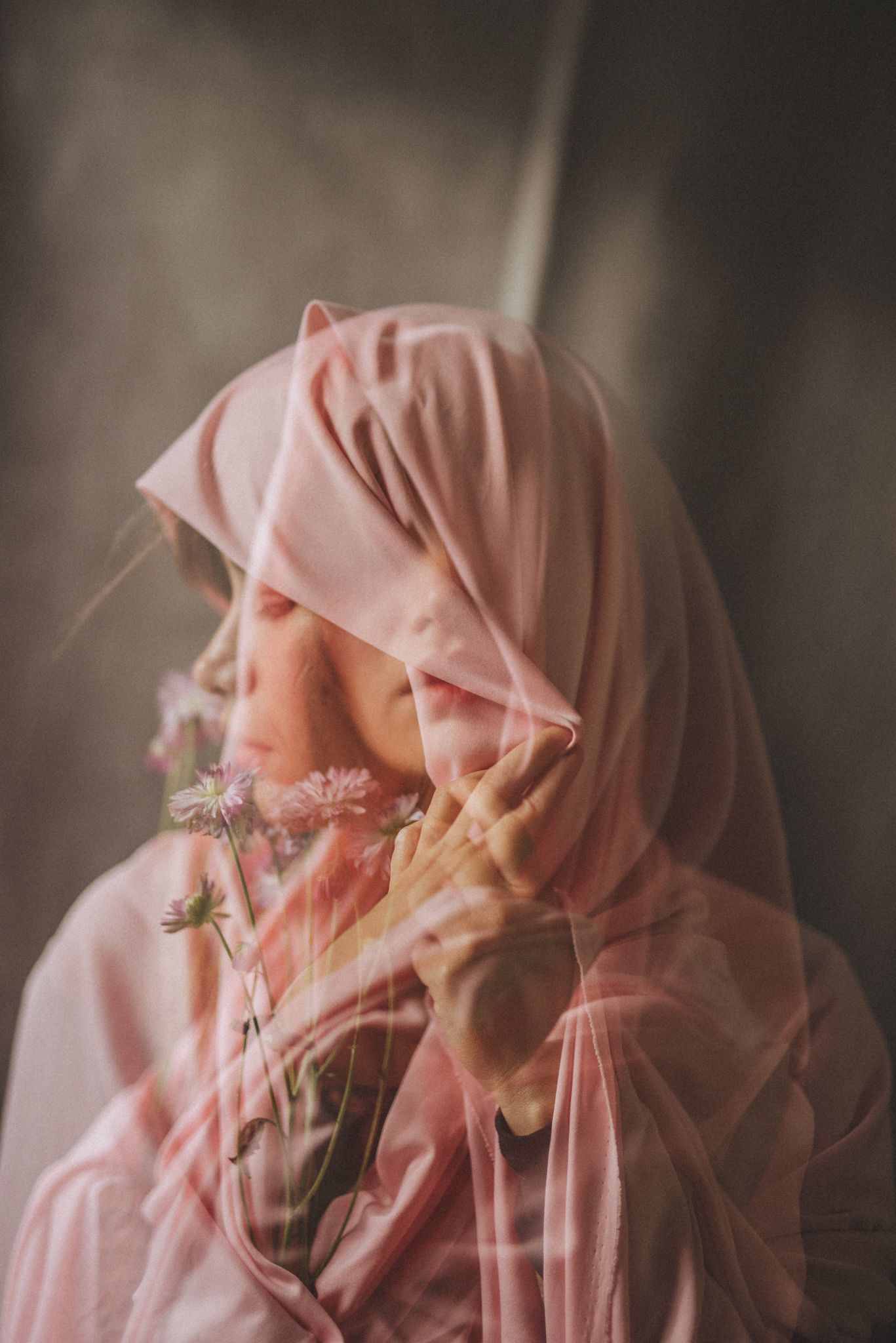 Ethereal portrait of person in pink hijab with soft side lighting.