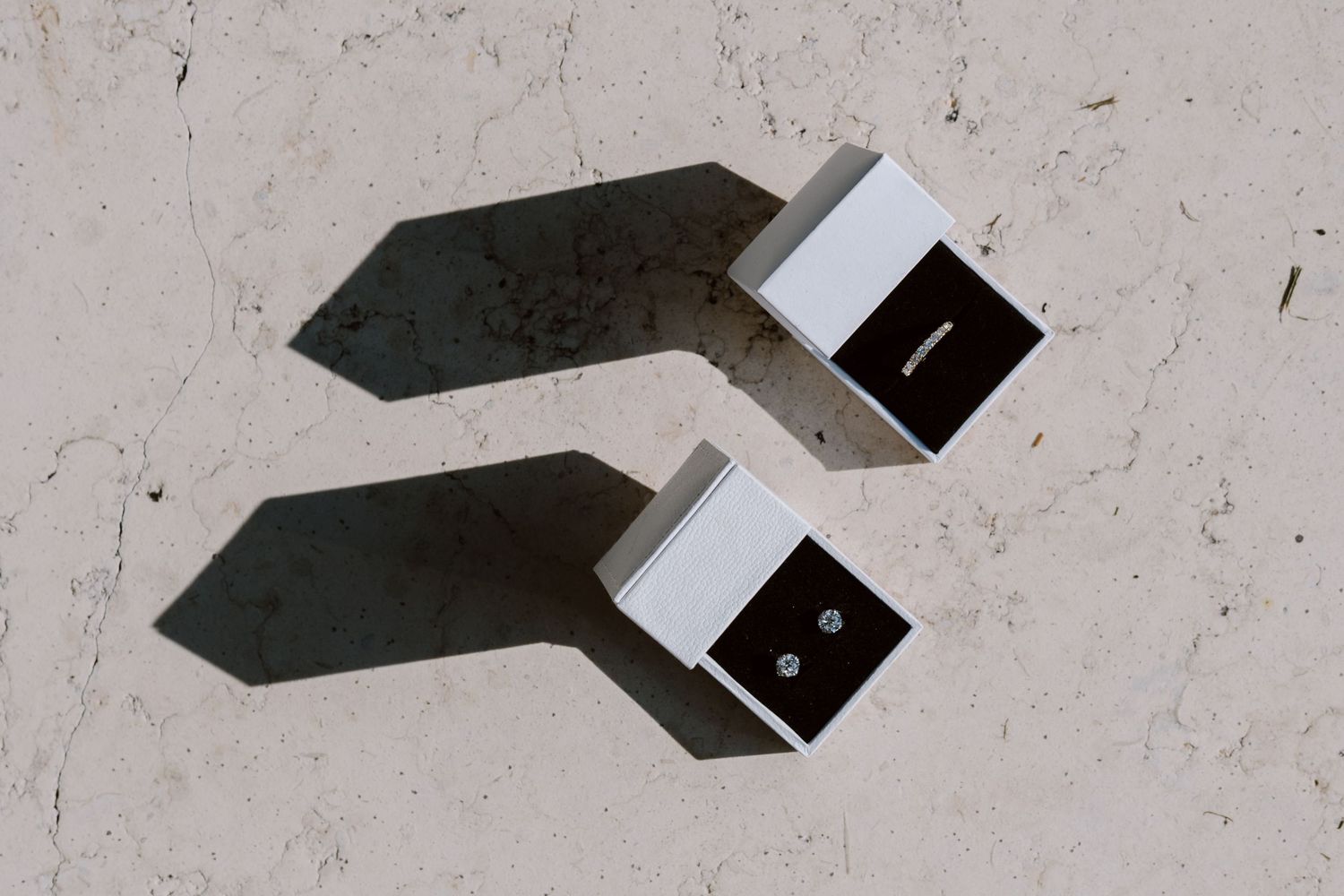 Two black ring boxes casting dramatic shadows on light surface.