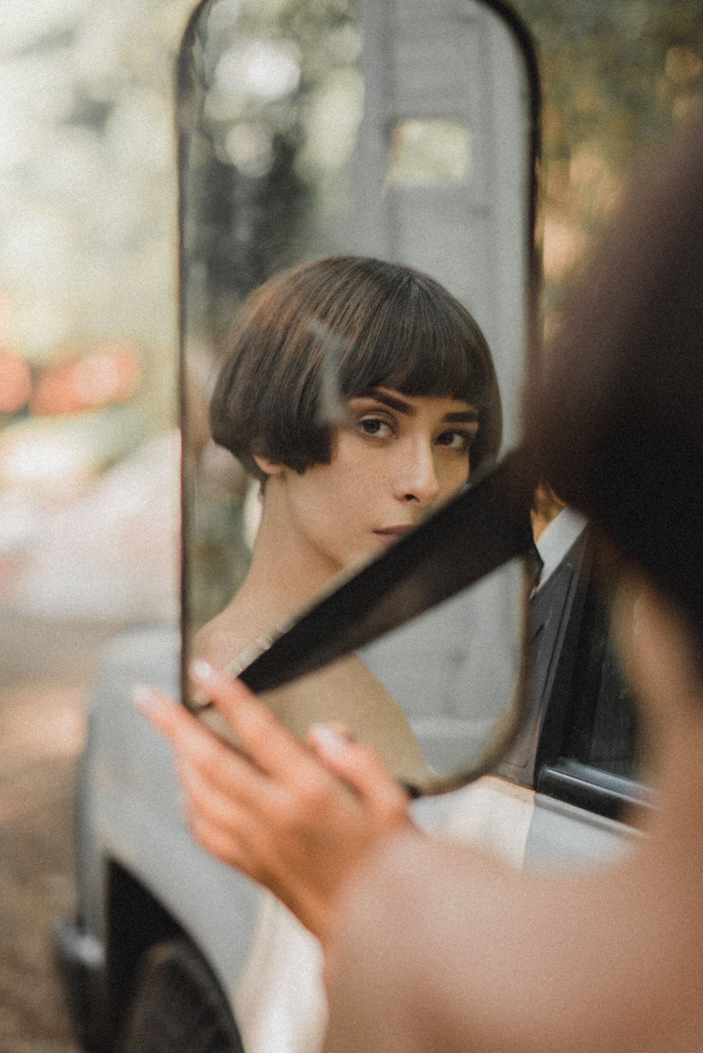 Close-up mirror reflection portrait with soft natural lighting and bokeh.