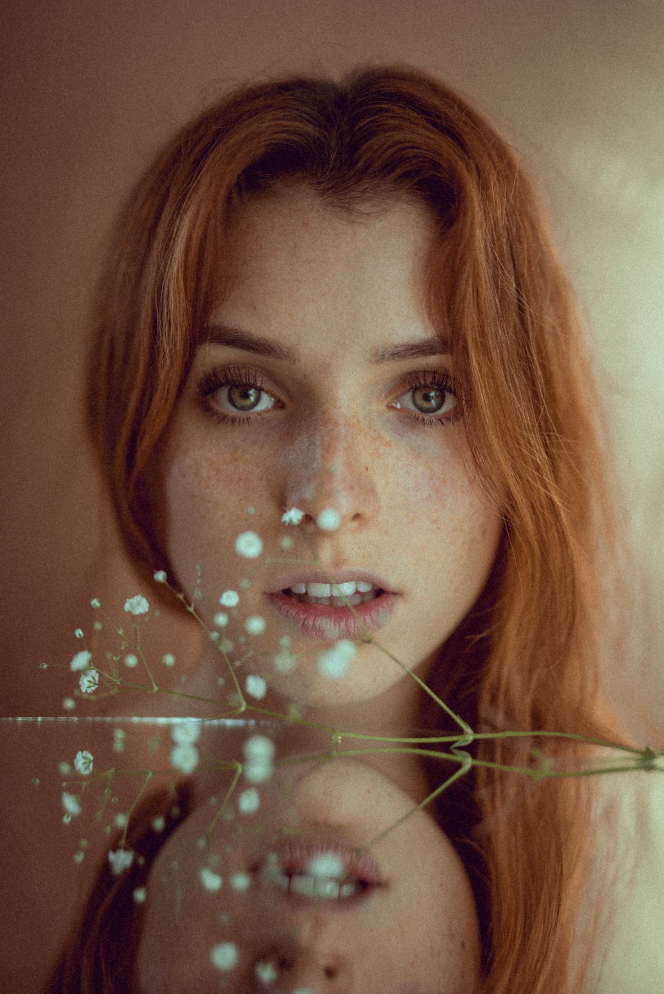 Ethereal portrait with baby's breath flowers creating dreamy bokeh effect.