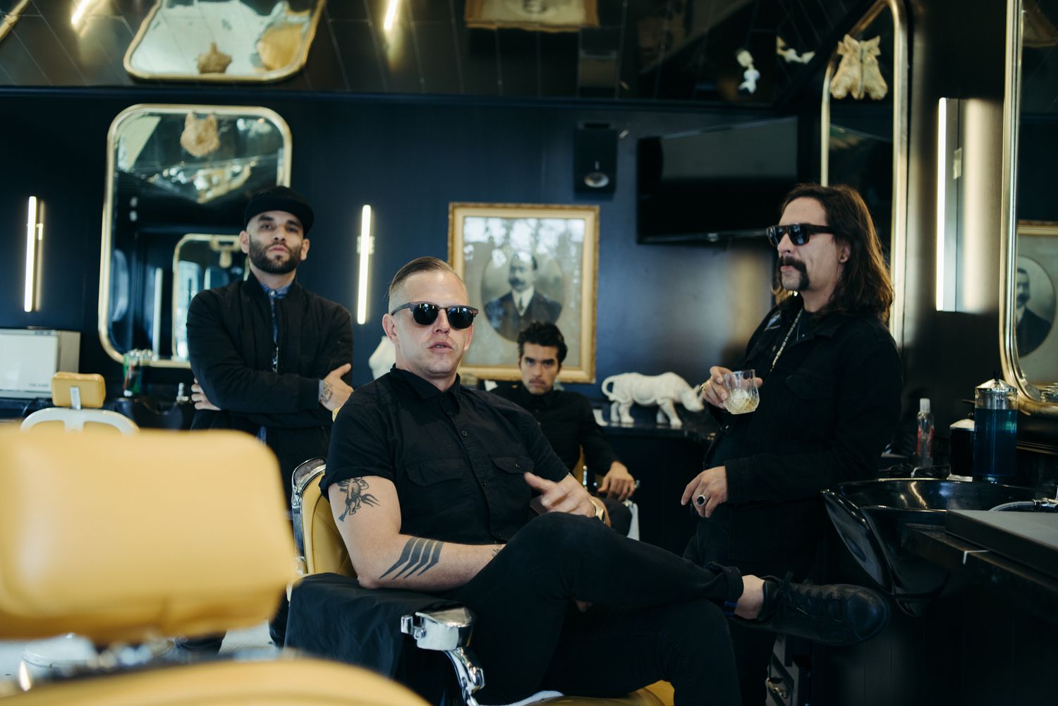 People in black attire engaged in conversation at trendy salon space.