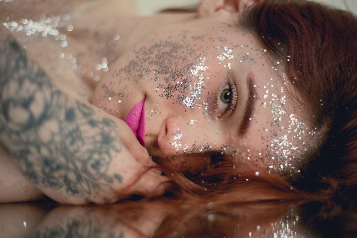 Artistic beauty portrait with pink lips and glitter against soft background.