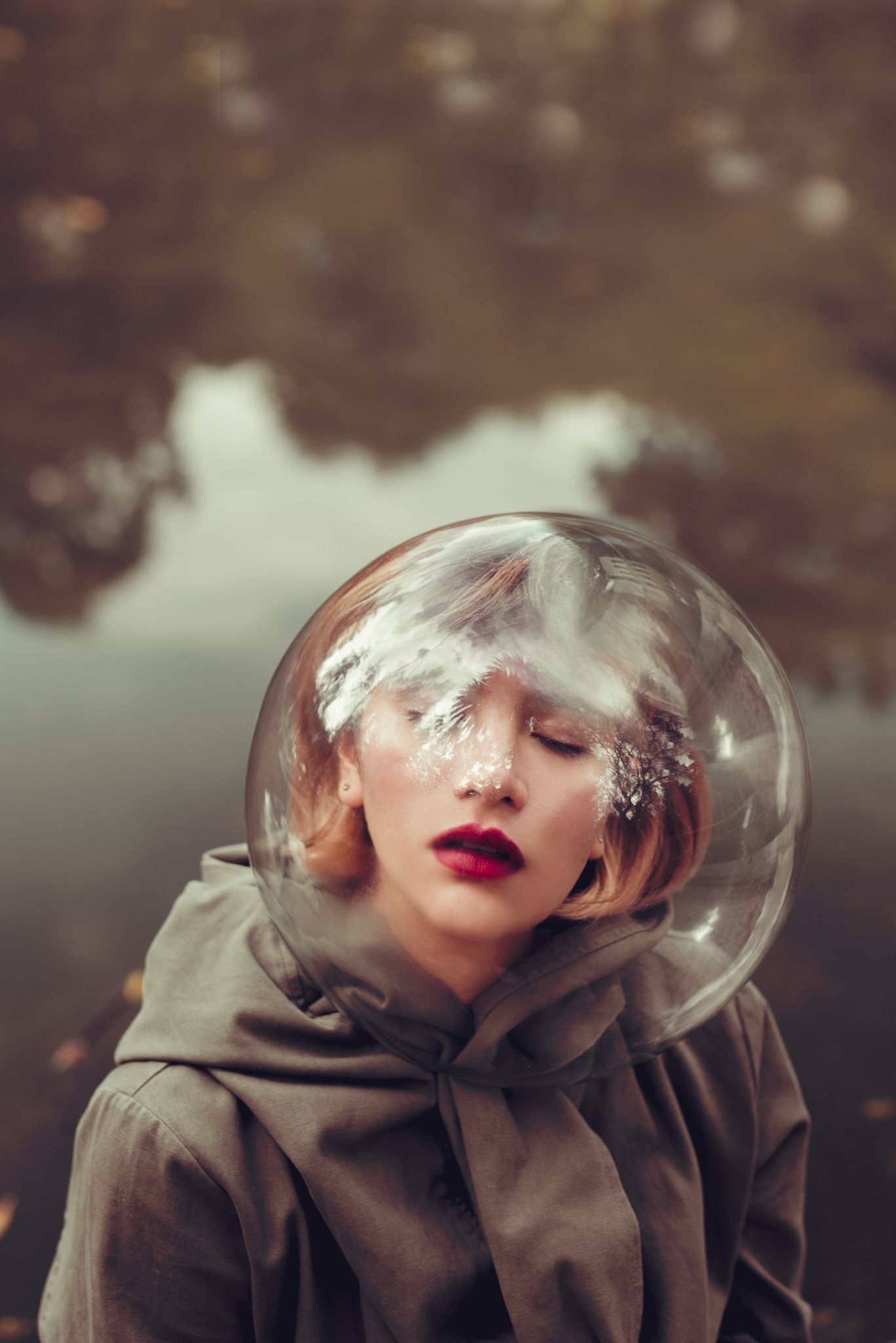 Artistic portrait with person wearing glass bubble helmet and red lipstick.
