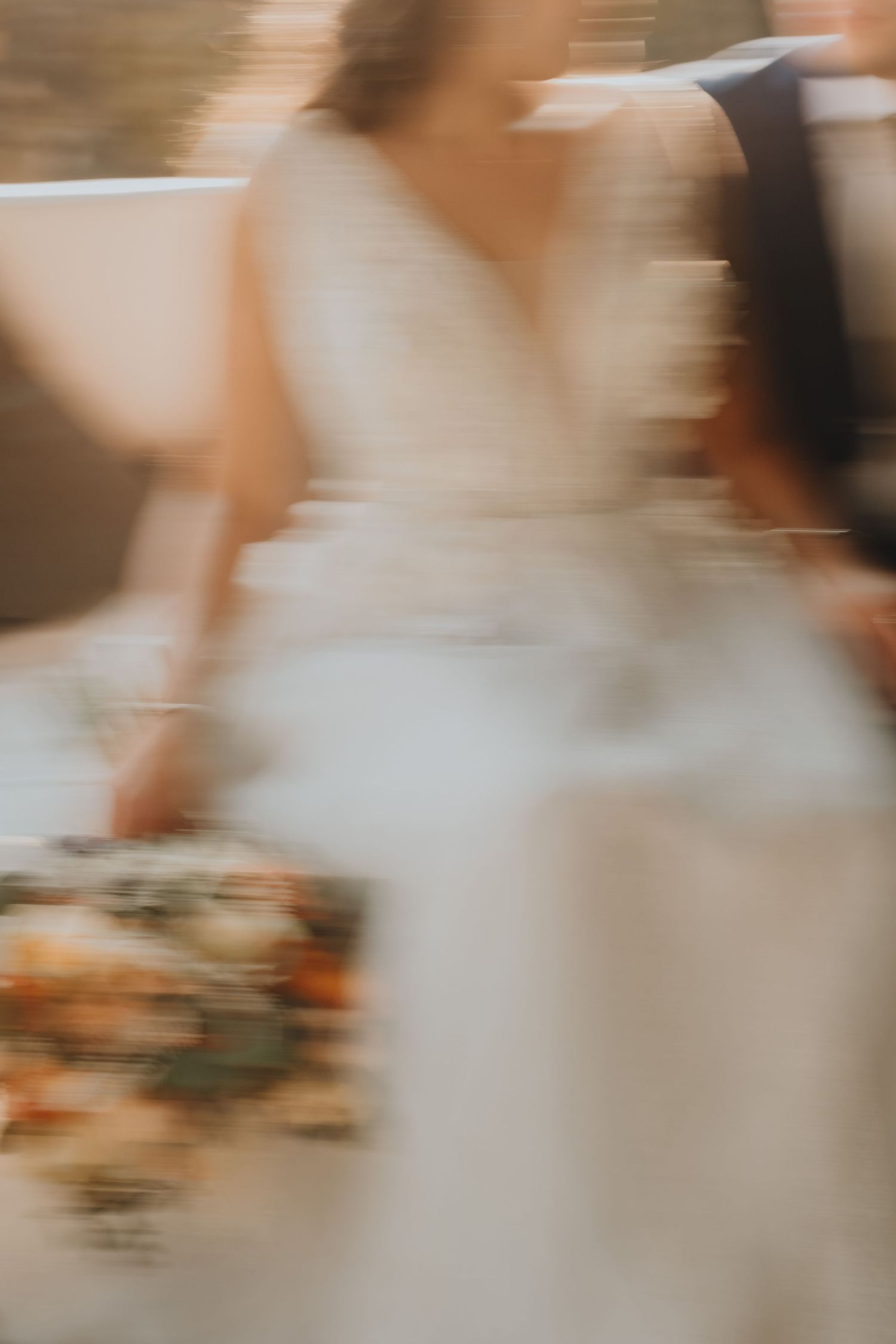Abstract motion blur of a wedding dress and bouquet creating an artistic effect.
