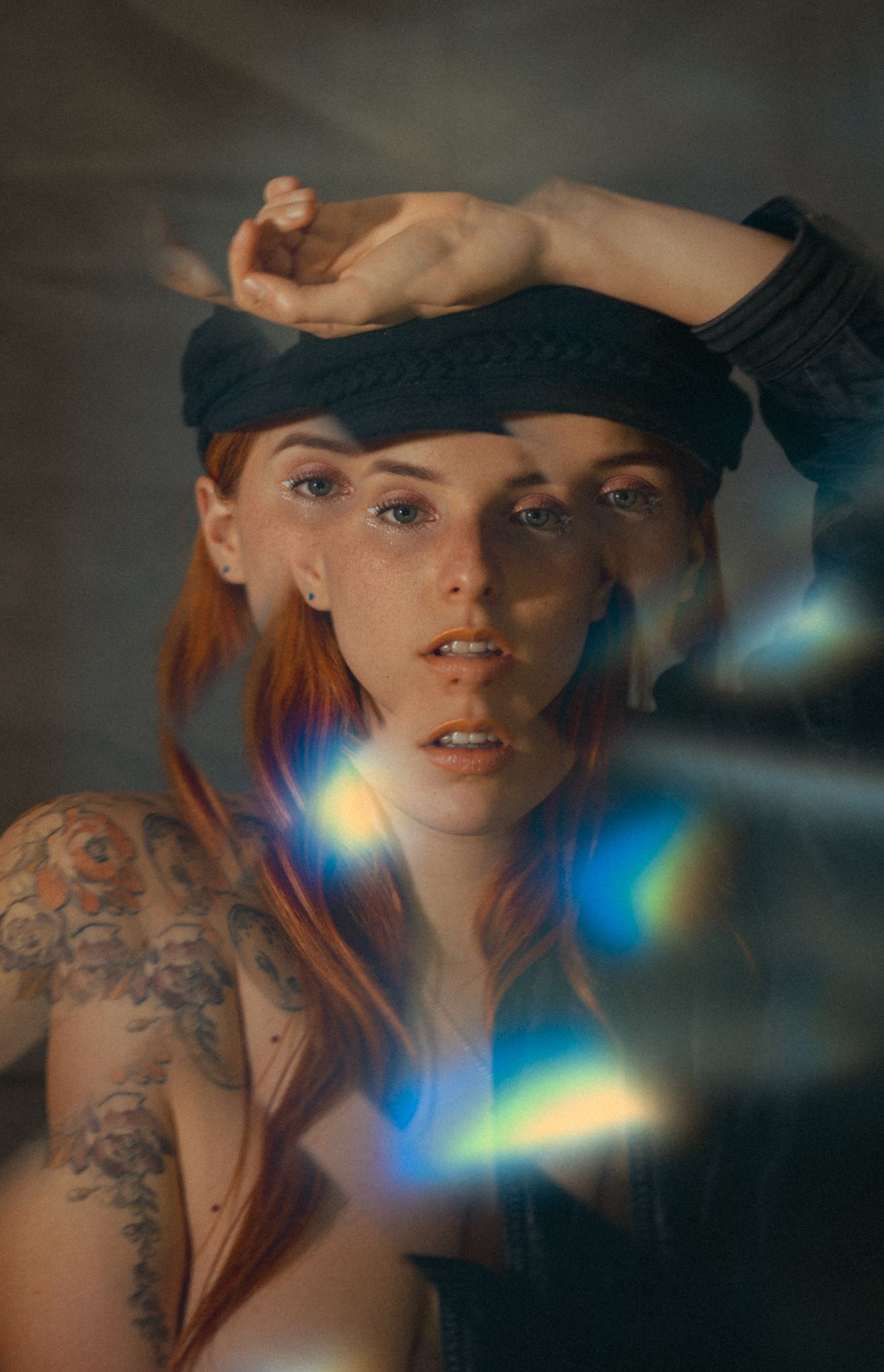 Artistic portrait with prismatic light effects and vintage cap styling.