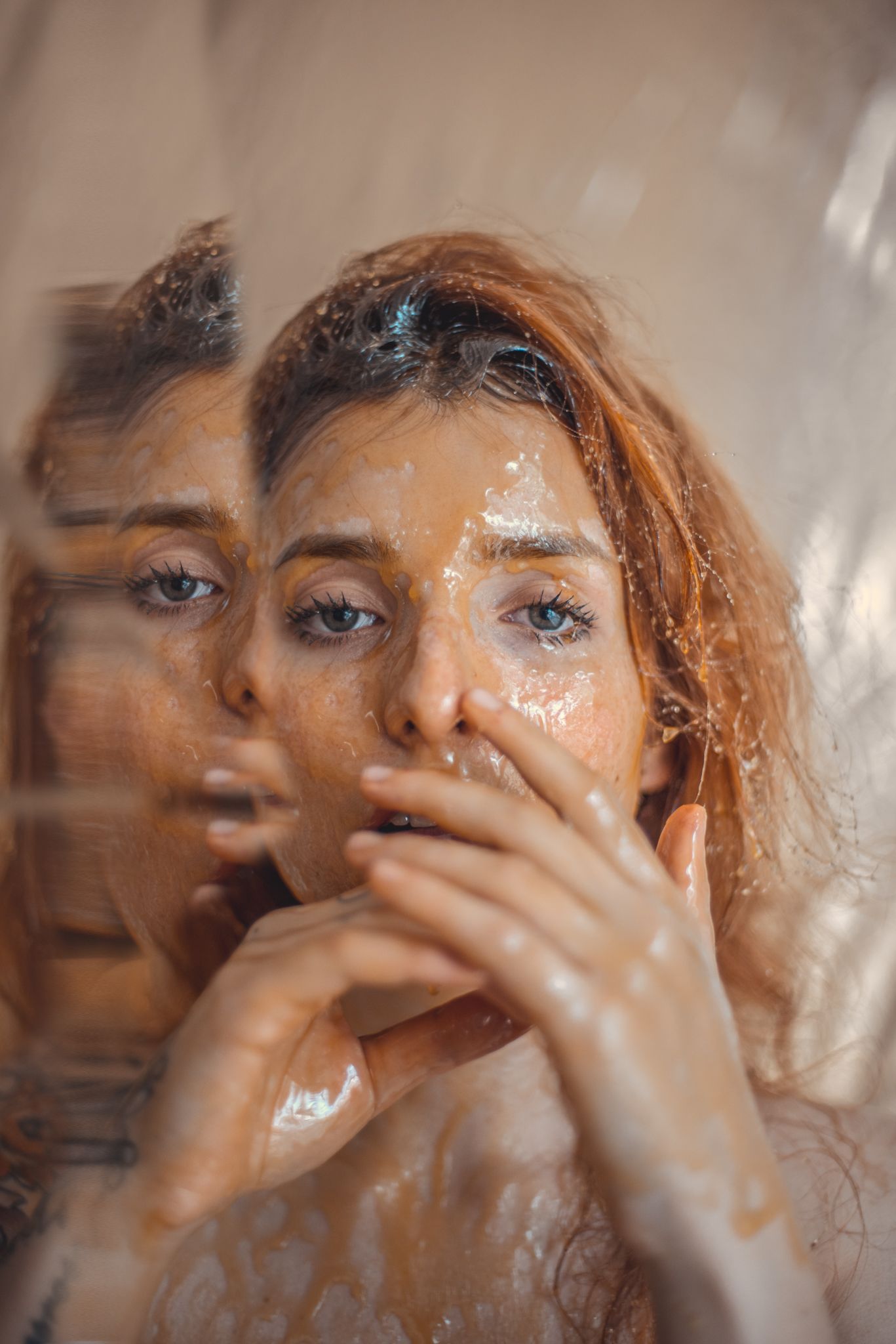 Artistic double exposure portrait with water droplets and motion blur effects.