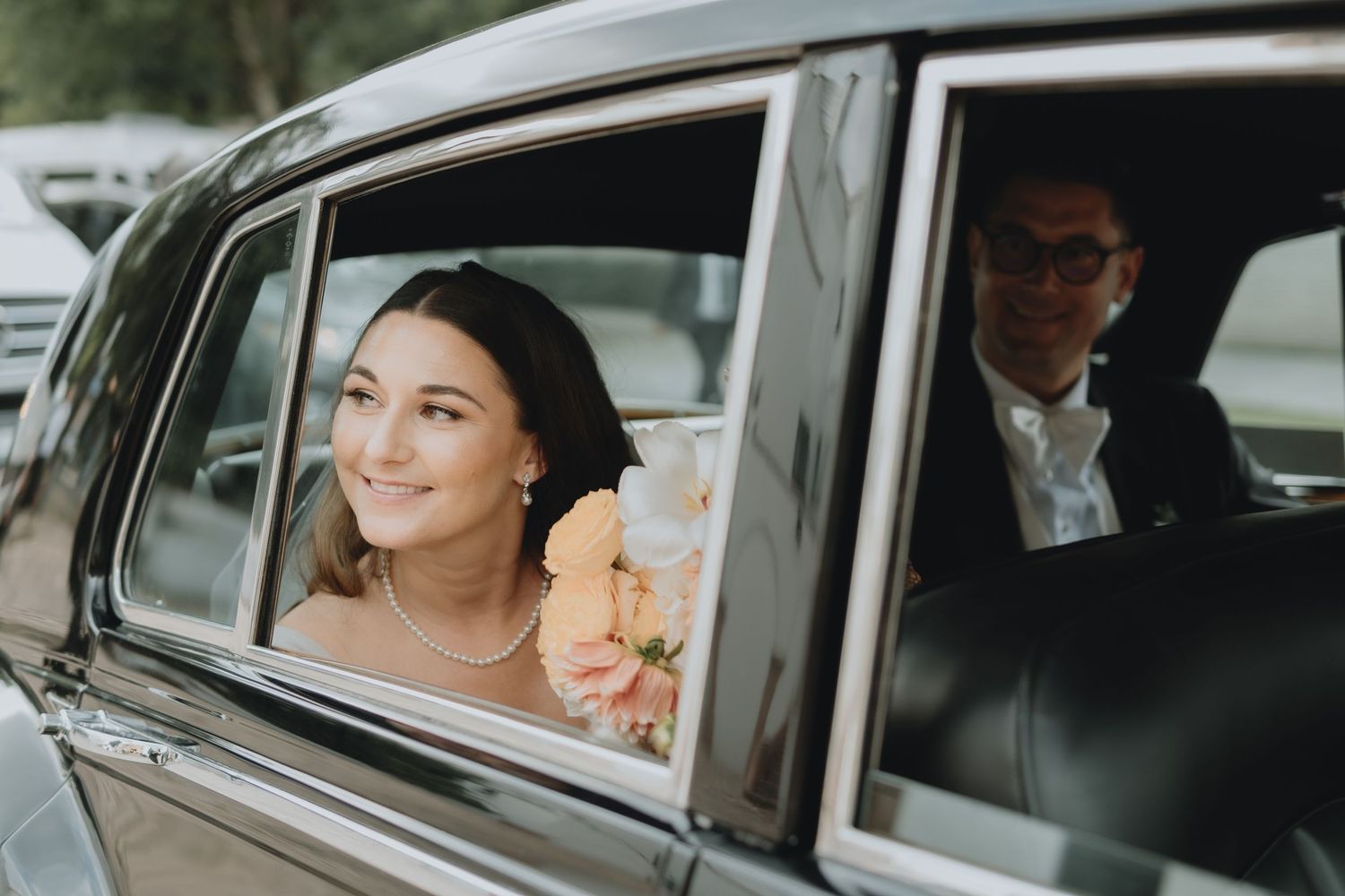 A classic car interior view shows a happy passenger on their wedding day.