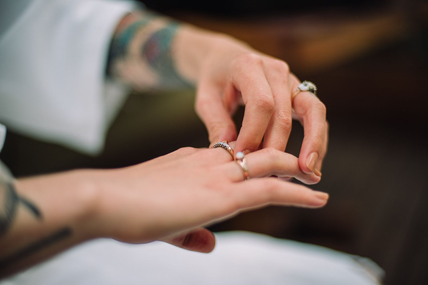 Close-up of hands exchanging rings during a wedding ceremony with a gentle exchange of the bands.
