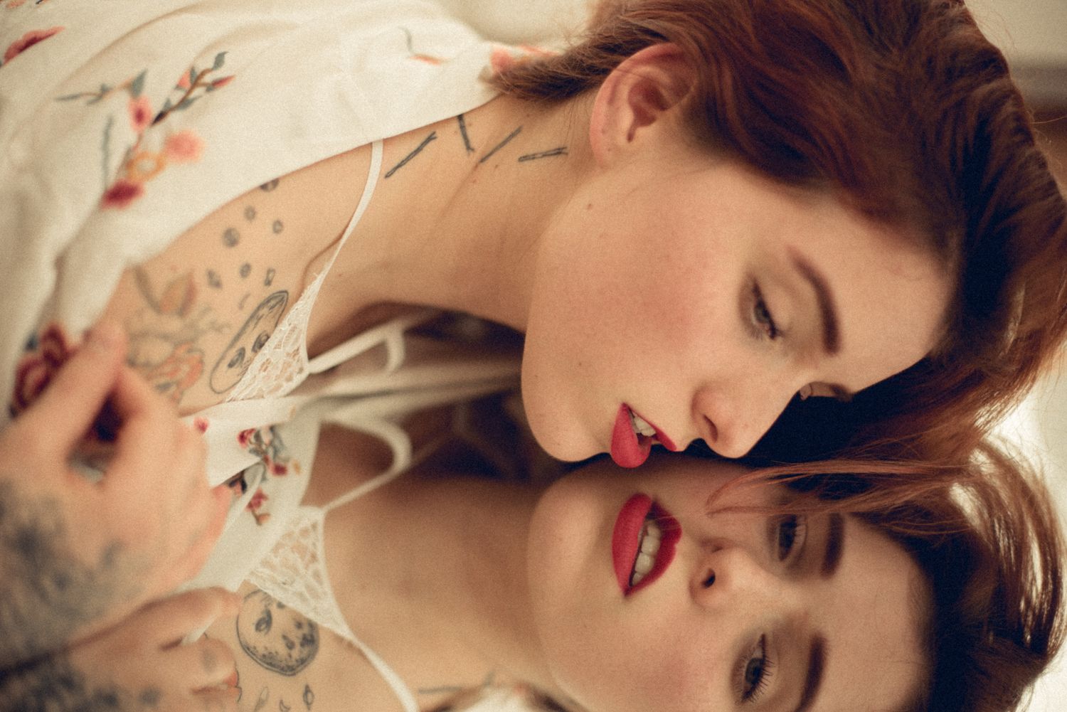 Intimate artistic portrait with soft lighting and delicate lace details creates a romantic mood.