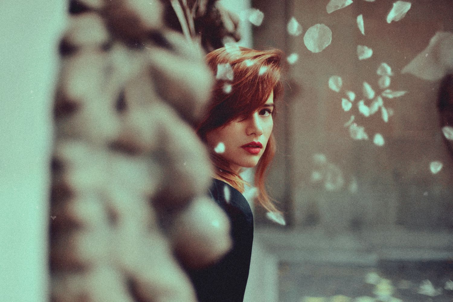 Artistic portrait with bokeh light effects in muted green tones.