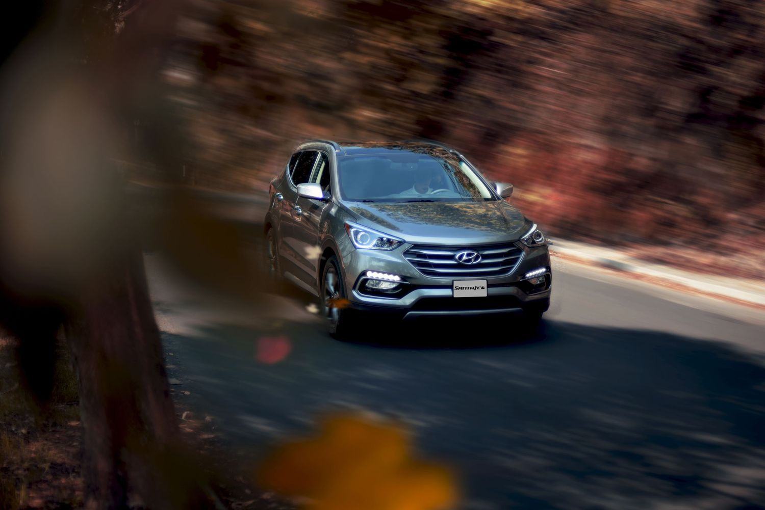 Modern Hyundai sedan photographed in motion on curved mountain road.