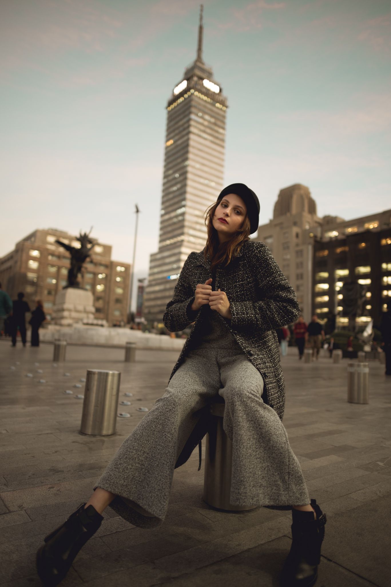 Fashion portrait near iconic Latin American Tower in Mexico City with wide leg pants and textured coat.
