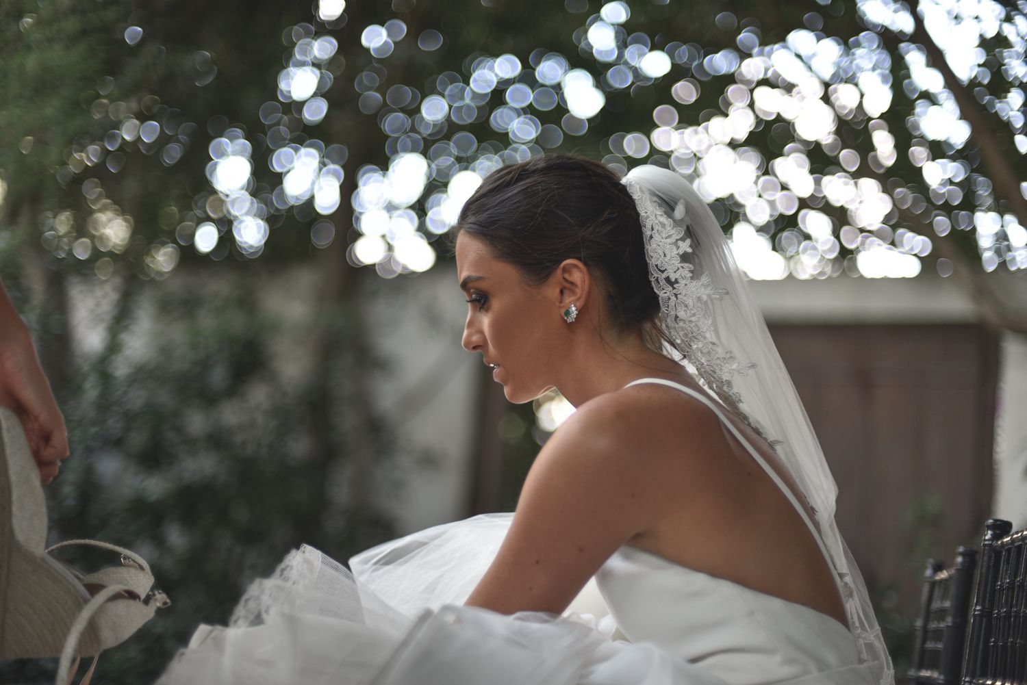 Wedding veil flowing in gentle breeze with bokeh effect in background.