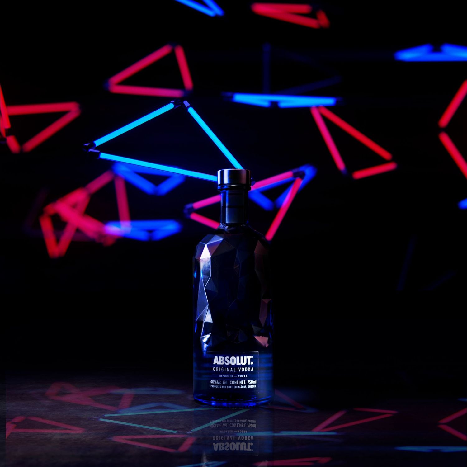 Abstract geometric pattern with intersecting red and blue glowing lines against dark background creating dynamic composition.