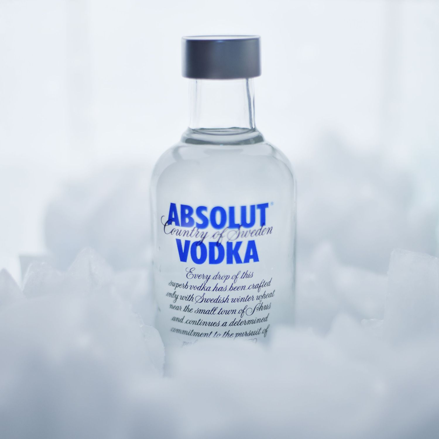 Three artistic close-up shots of Absolut vodka bottles showing partial logo text and frosted glass details.